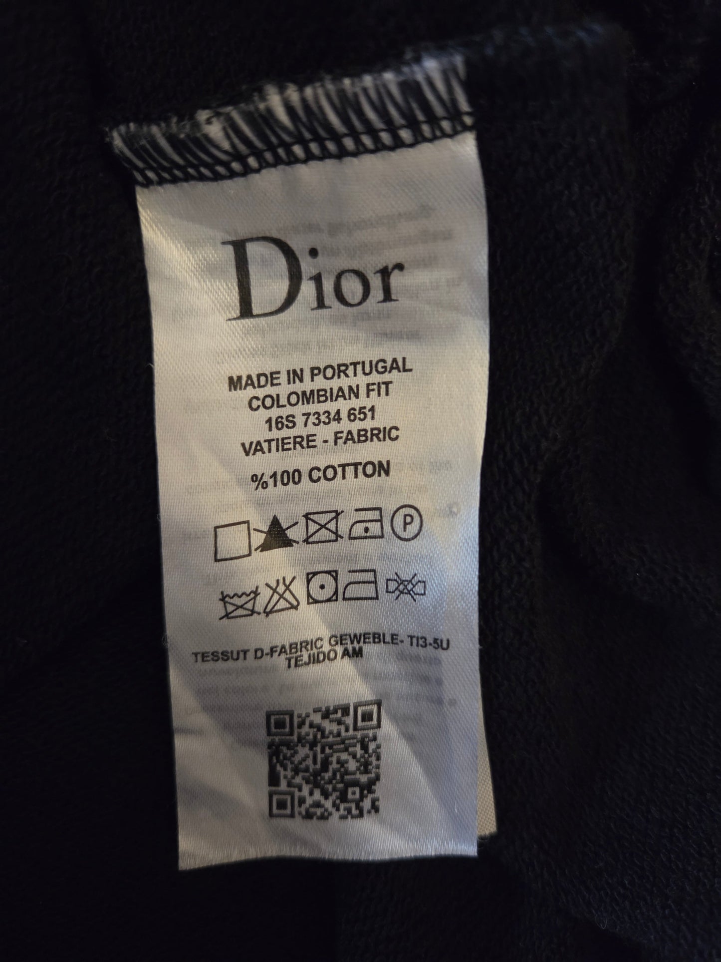 Dior label on a garment with text and symbols.