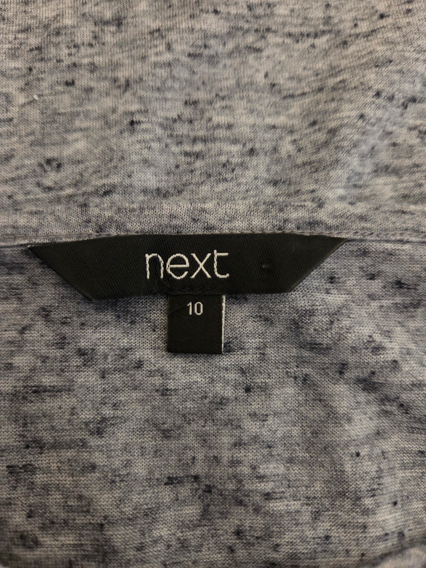 Close-up of a size tag with 'next' 