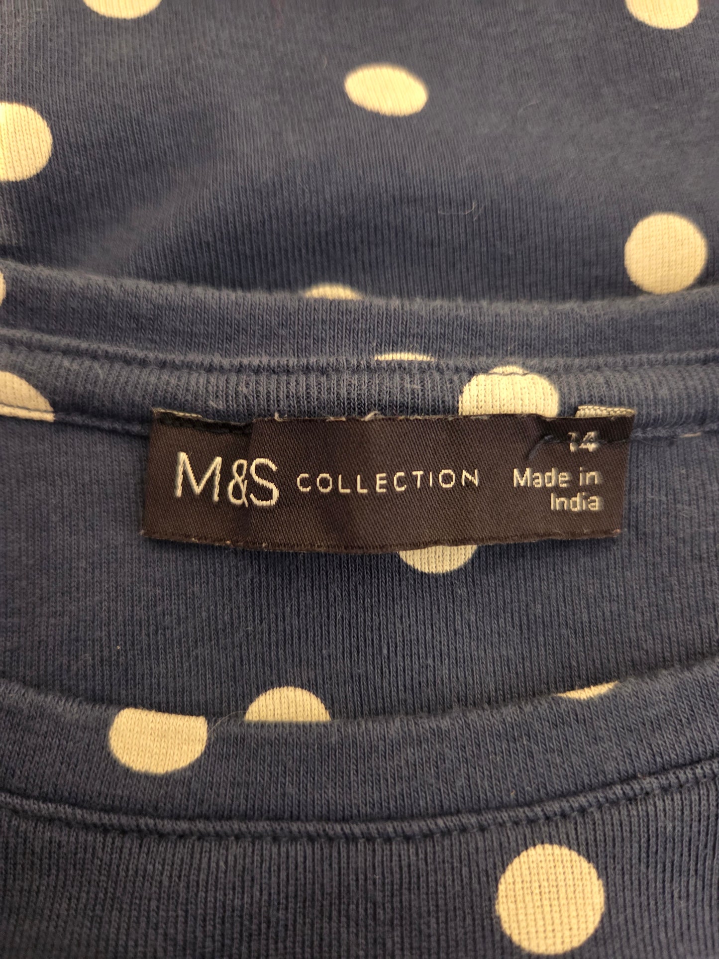 M&S Collection label on a navy blue fabric with white polka dots