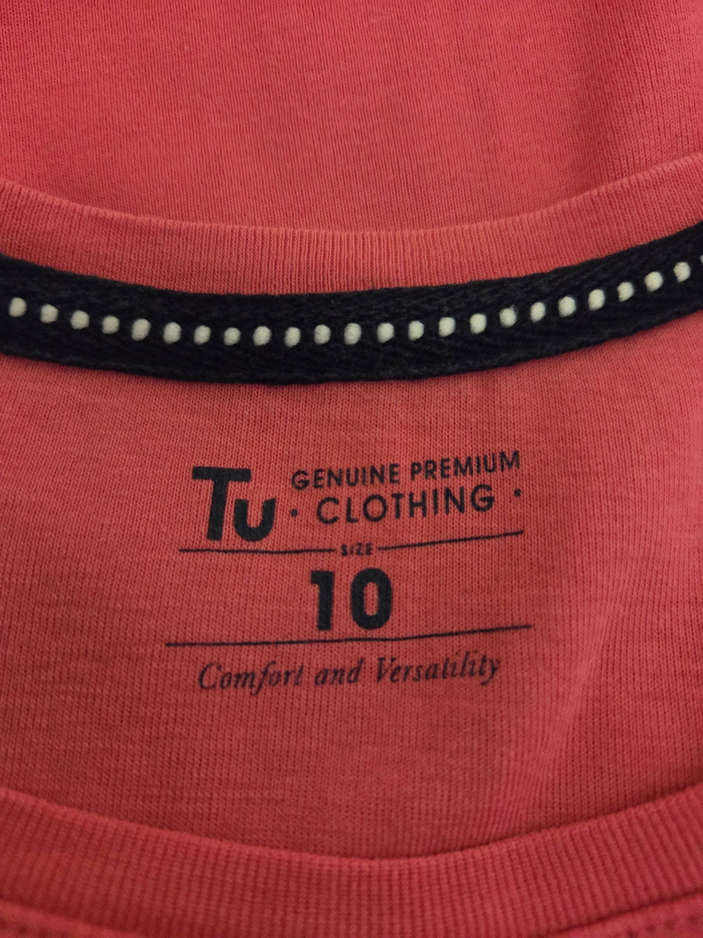 Close-up of a pink garment with 'TU Clothing' size label 