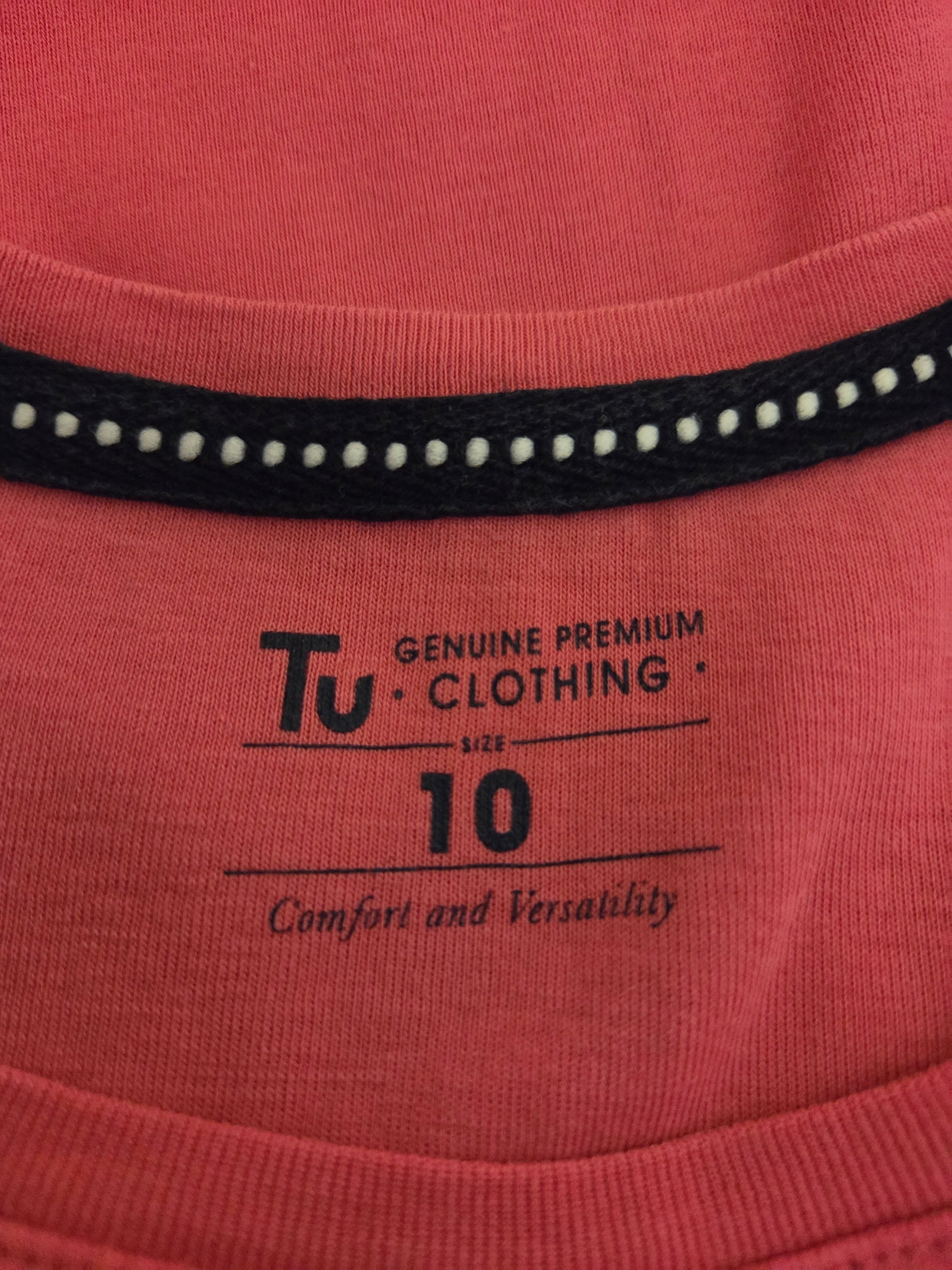 Close-up of a pink garment with 'TU Clothing' size label 