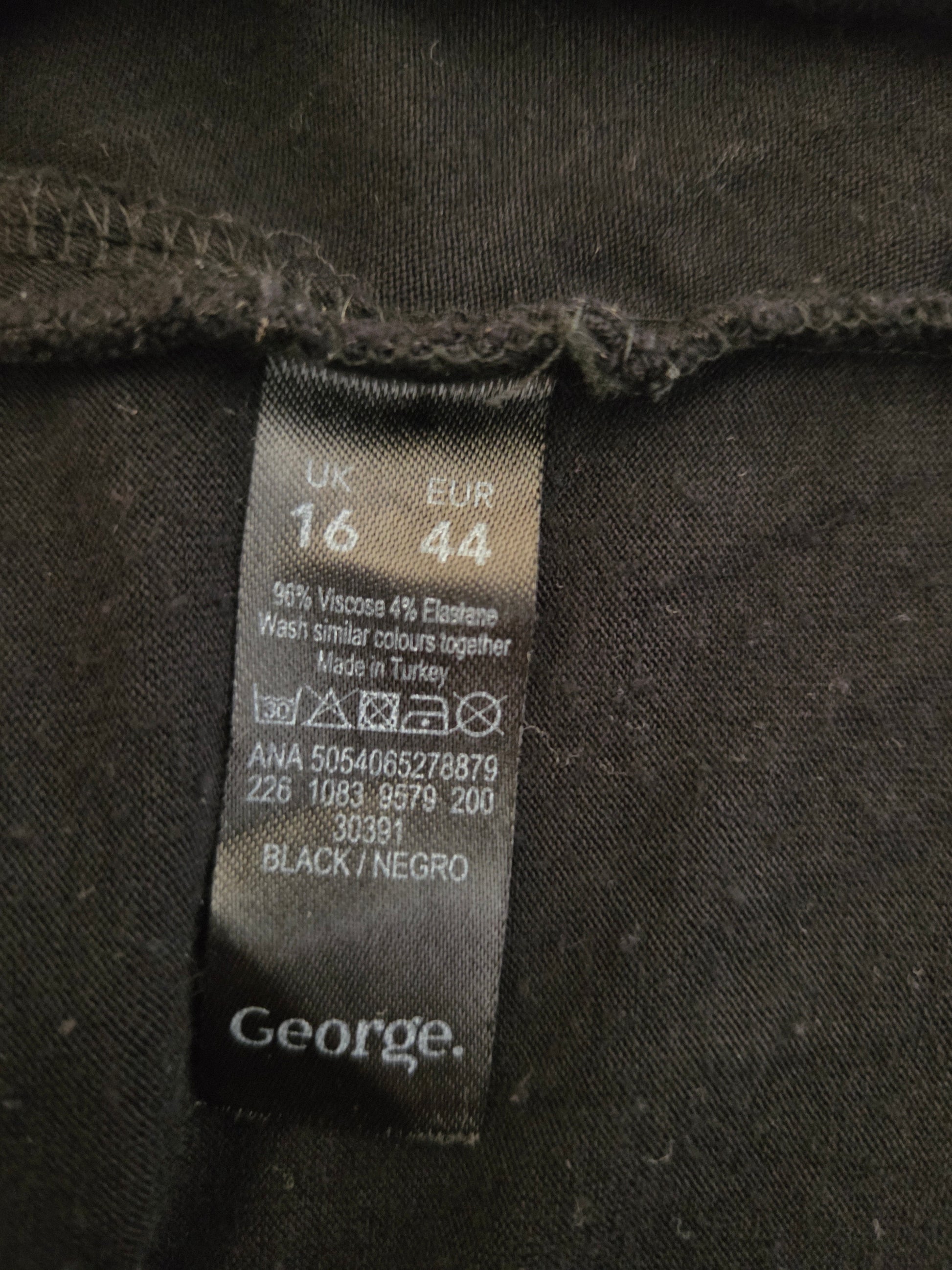 Clothing label on a dark fabric with brand name 'George'.