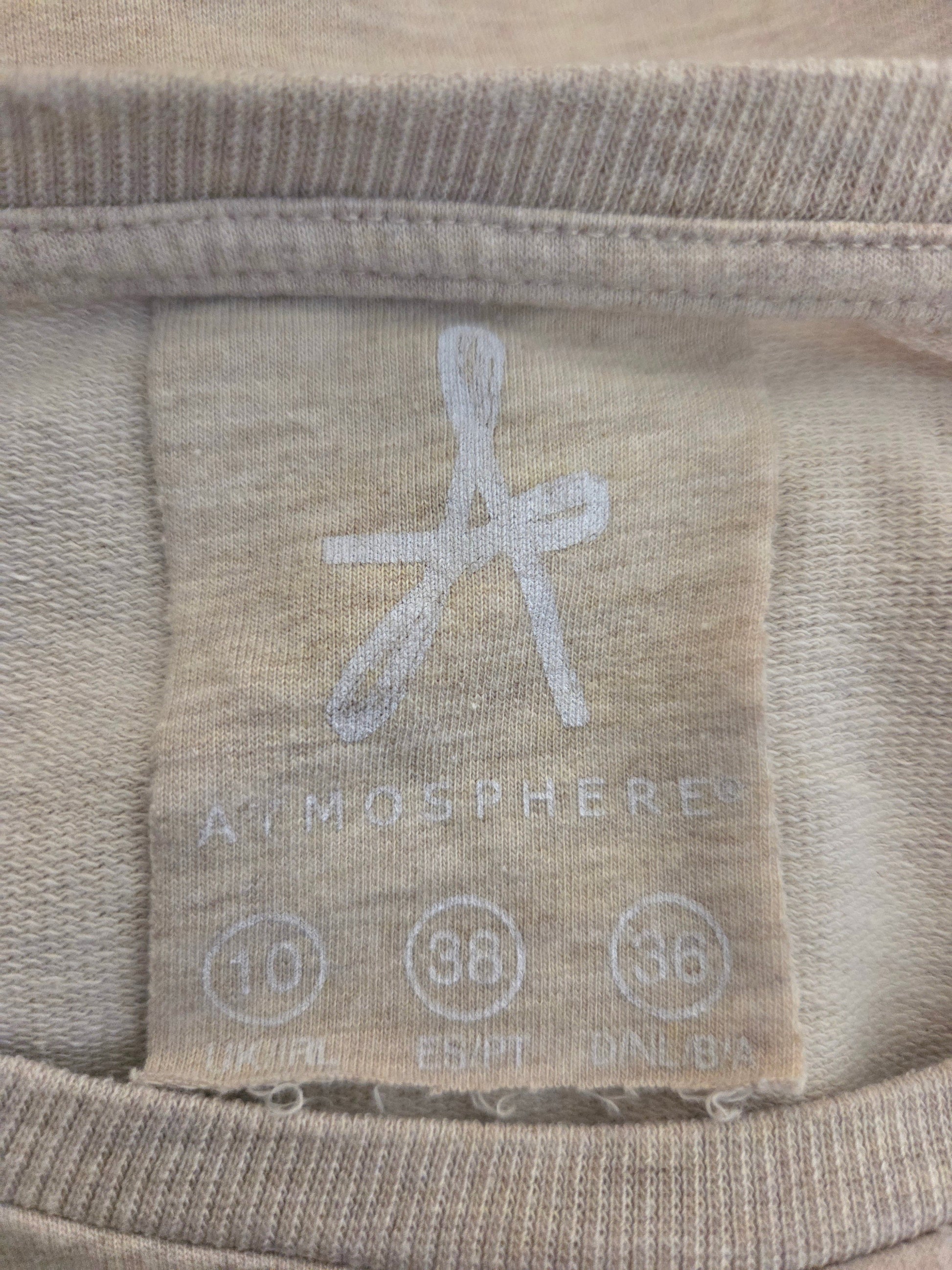 Close-up of a fabric label with 'Atmosphere' branding on a beige background