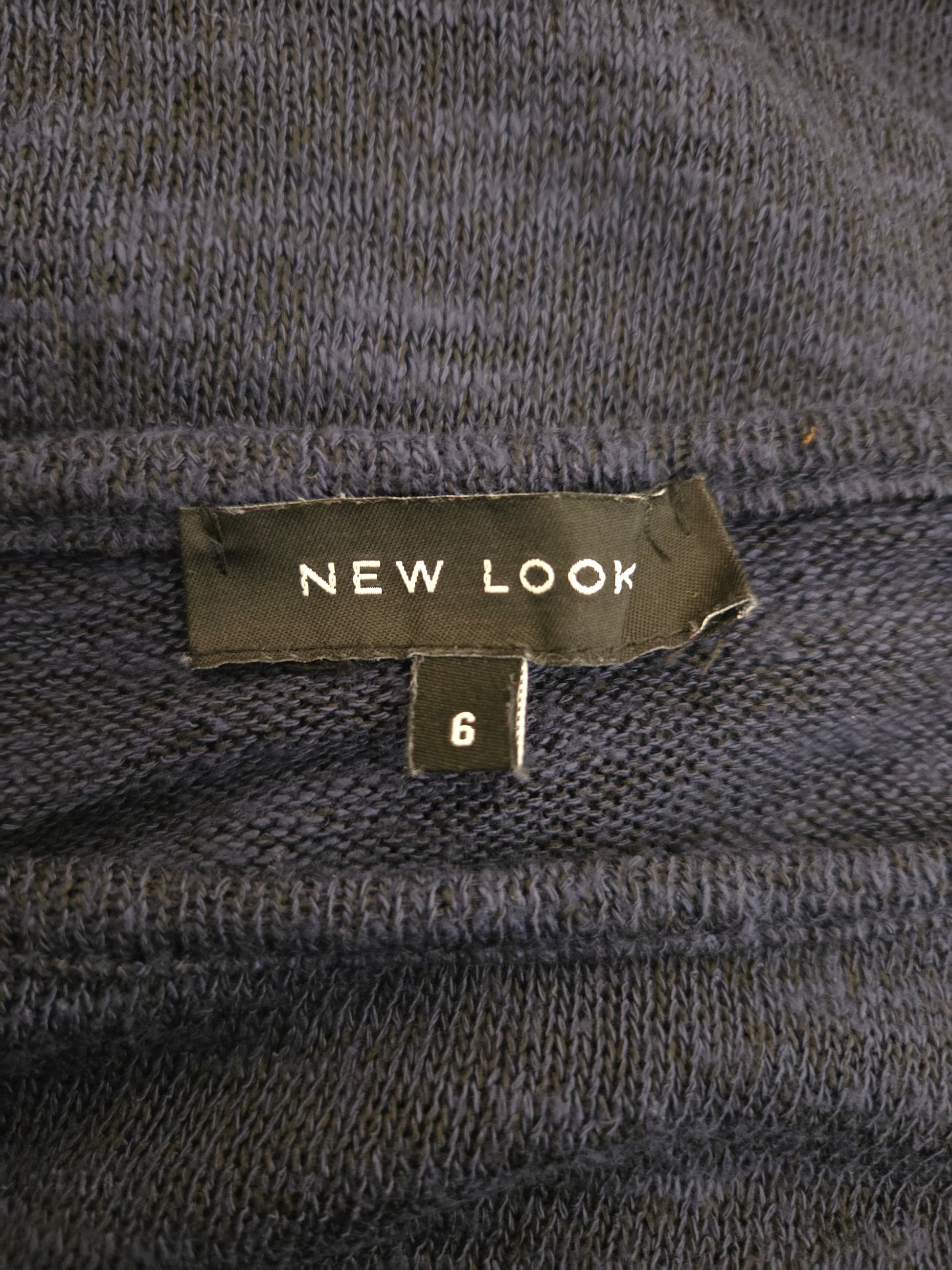 Close-up of a 'New Look' size label on a textured fabric background