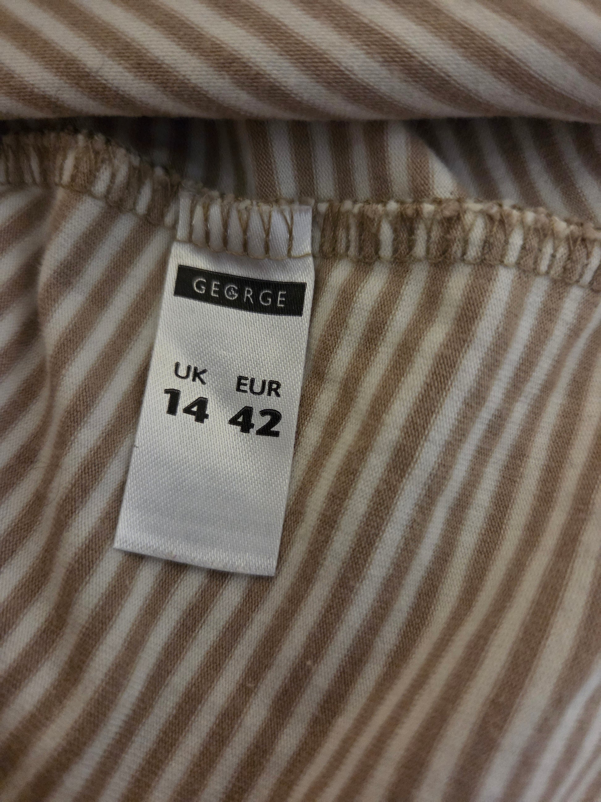 Close-up of a size tag on a striped fabric background