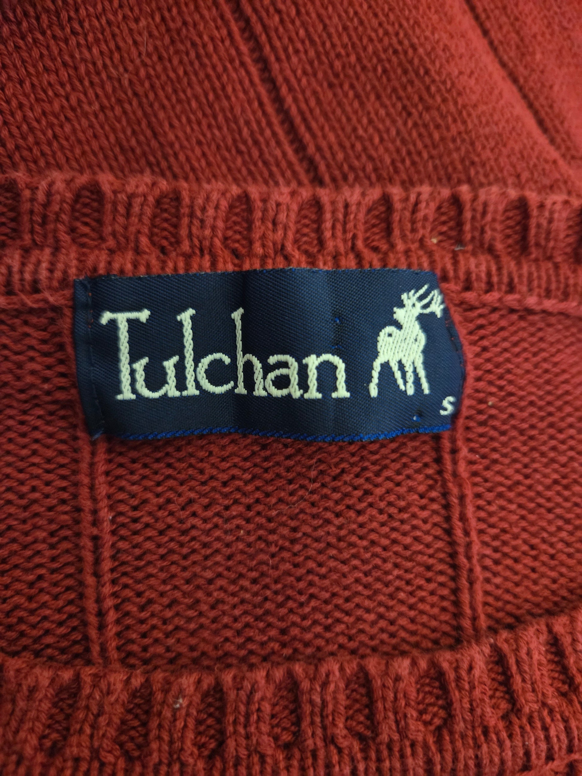 Close-up of a red fabric with a 'Tulchan' label featuring a deer logo.