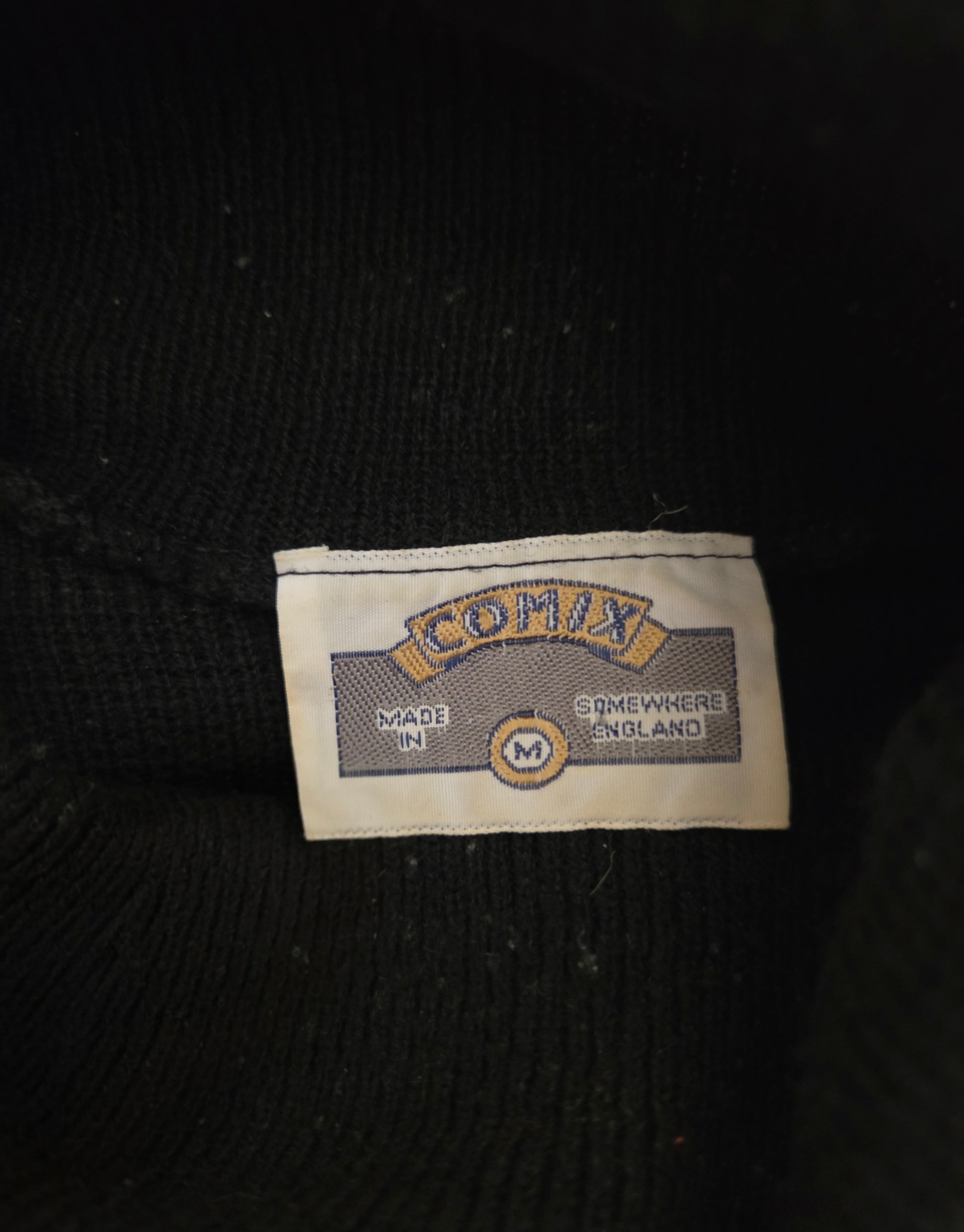 Close-up of a 'Comix' brand label on a black background