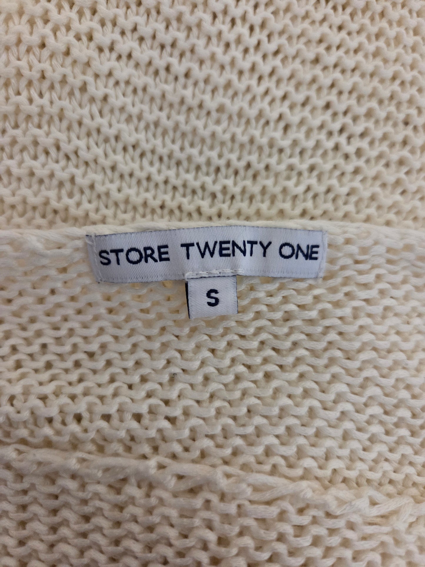 Size label on a beige knitted fabric with 'Store Twenty One' branding.
