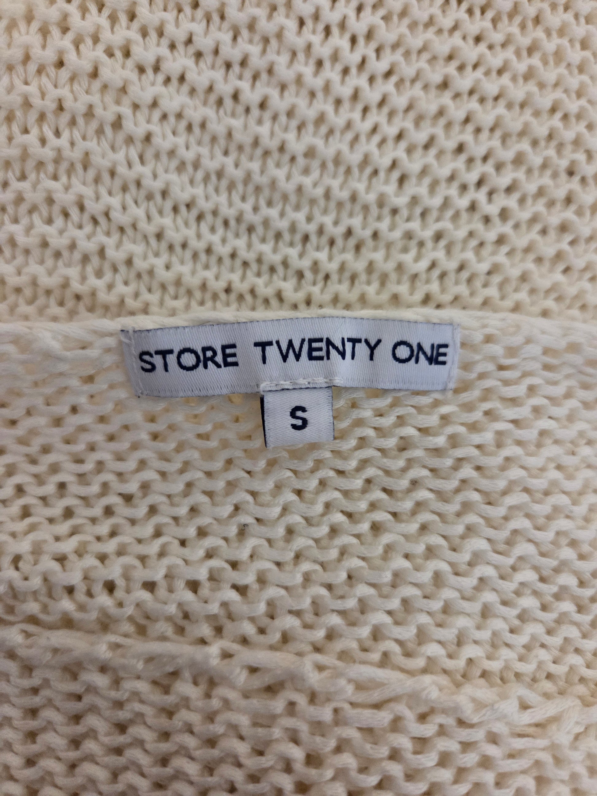 Size label on a beige knitted fabric with 'Store Twenty One' branding.