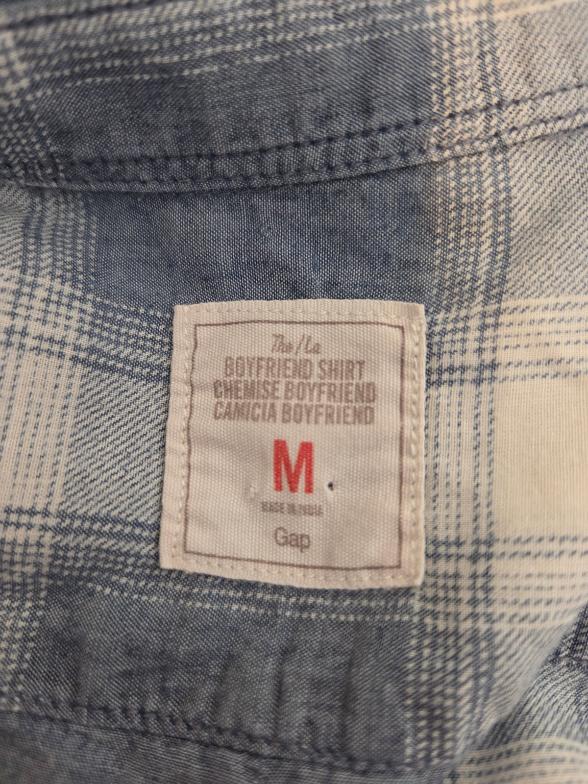 Close-up of a plaid shirt with a Gap label on a checkered fabric background