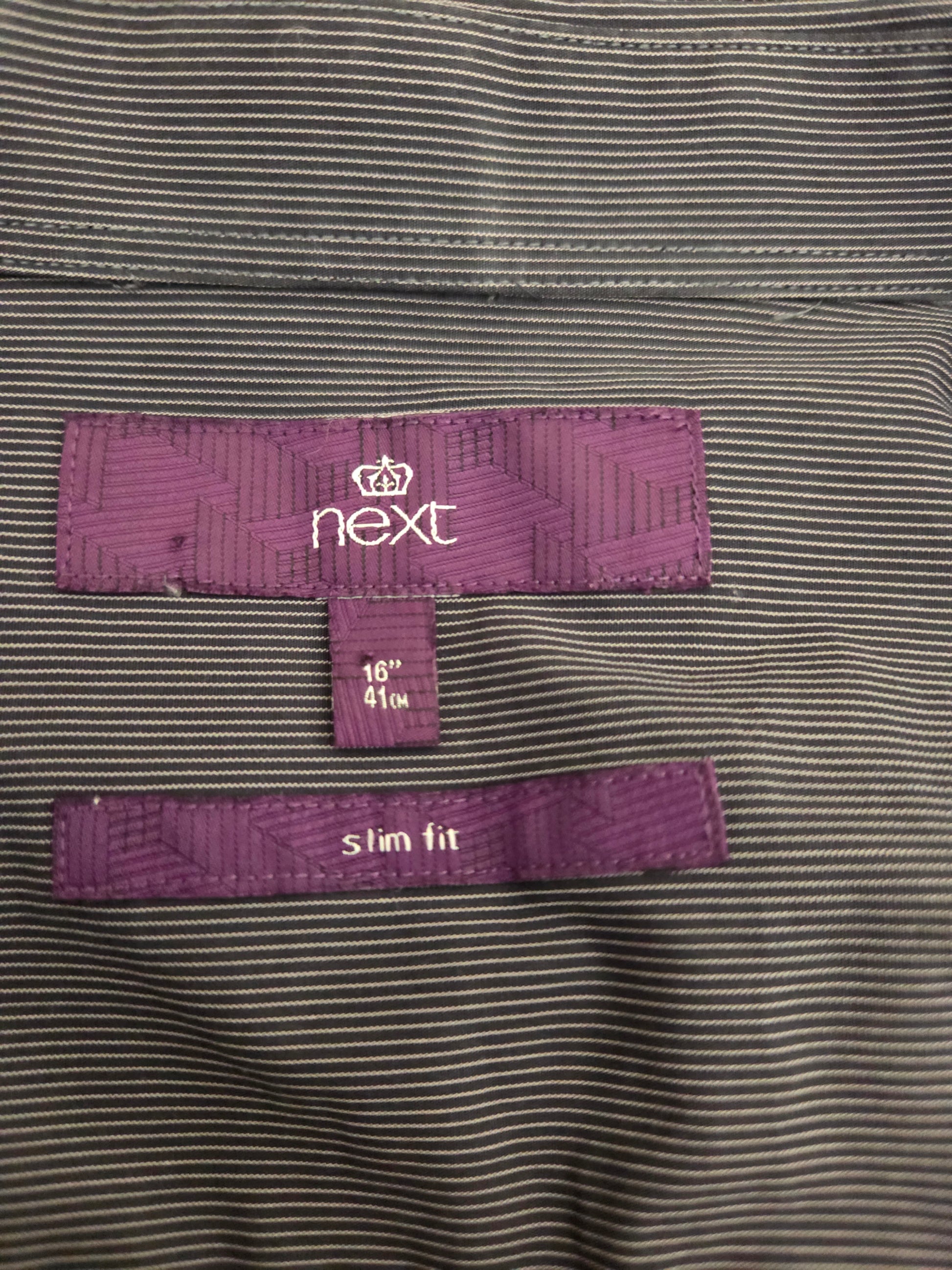 Close-up of striped fabric and purple label inside shirt