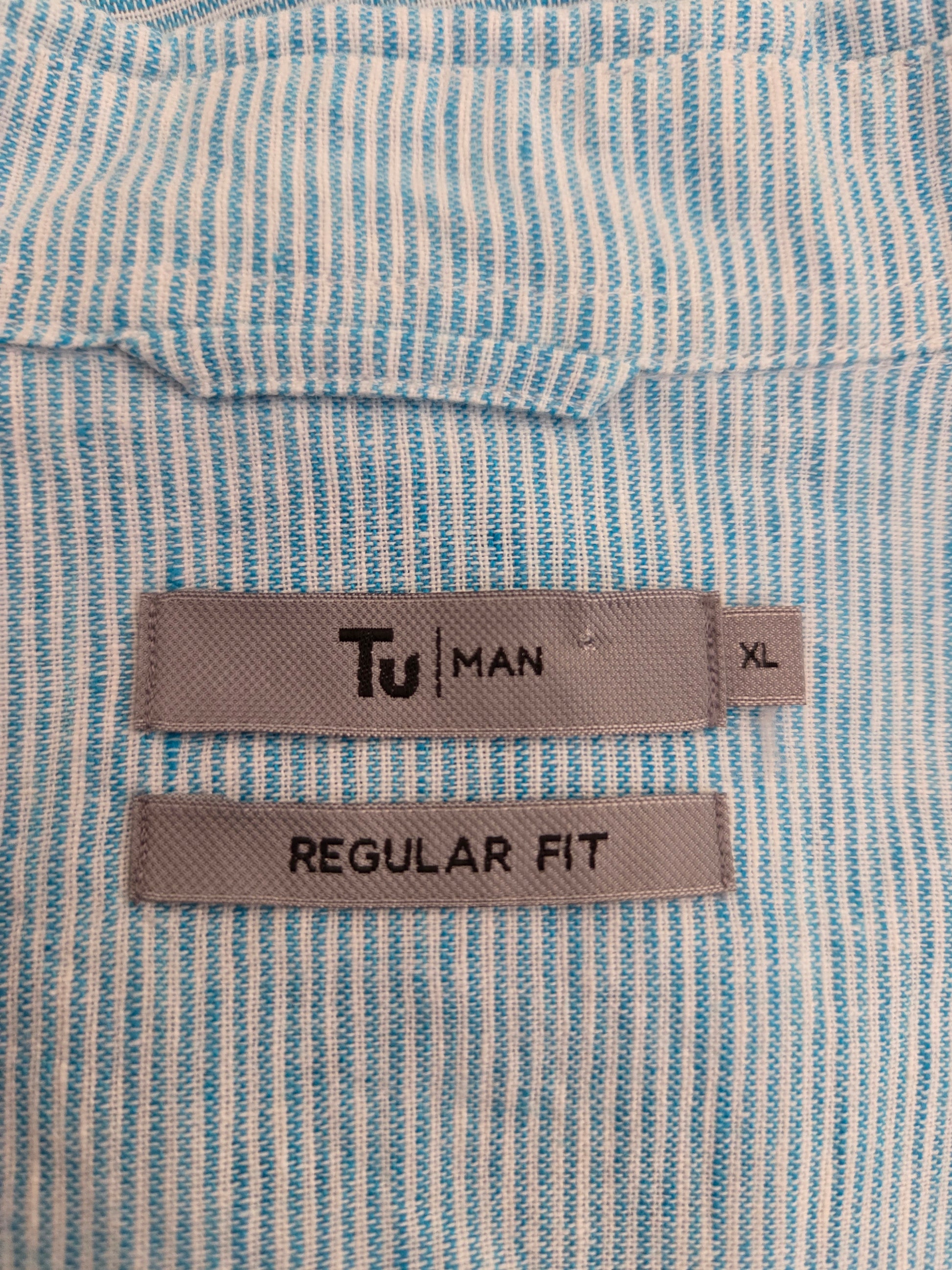 Close-up of light blue striped shirt fabric and label