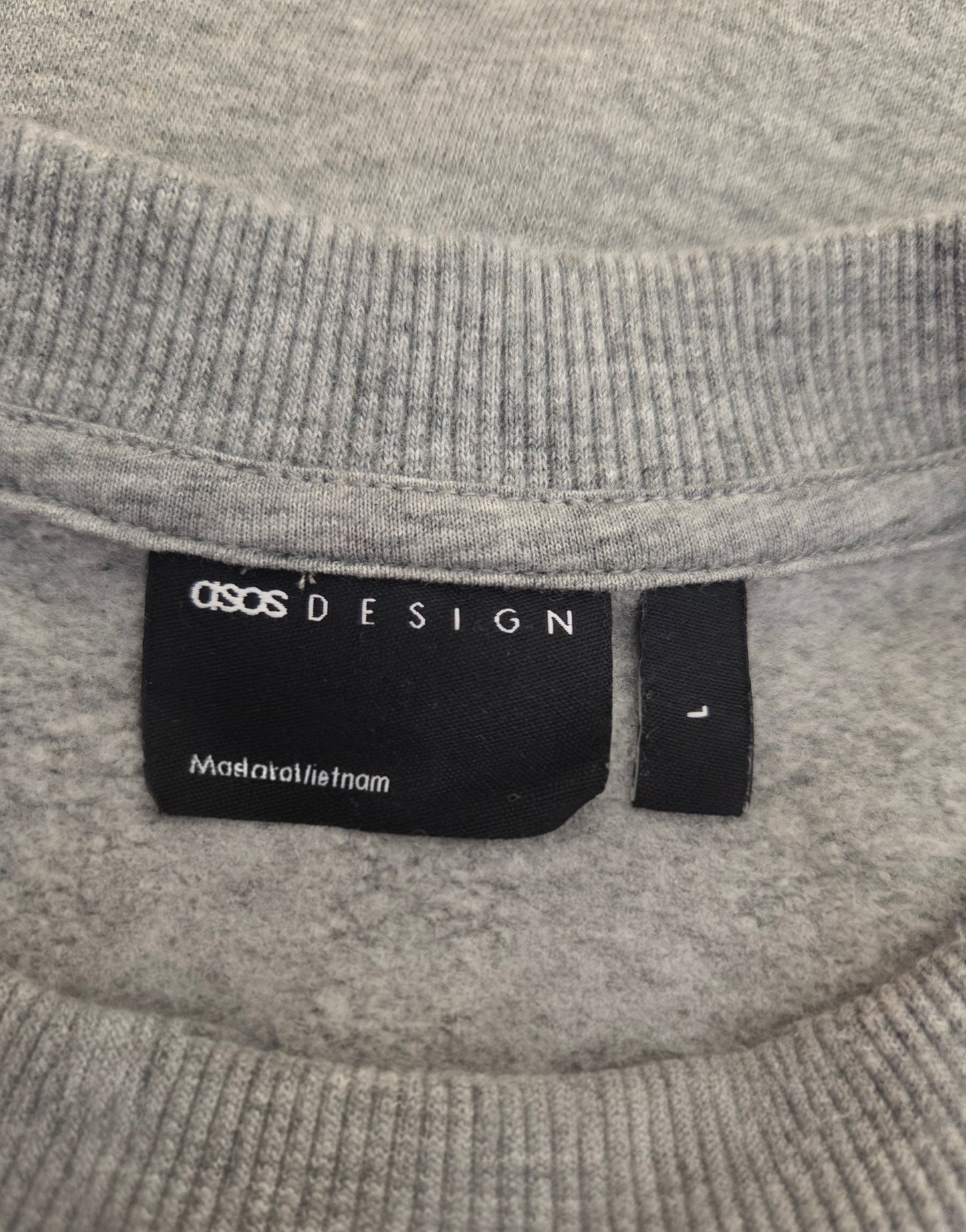 Gray sweater with a label on the collar