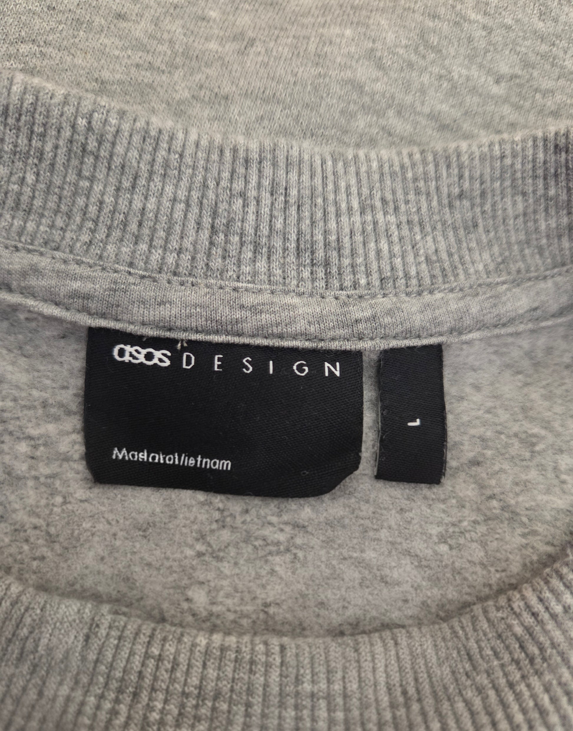 Gray sweater with a label on the collar