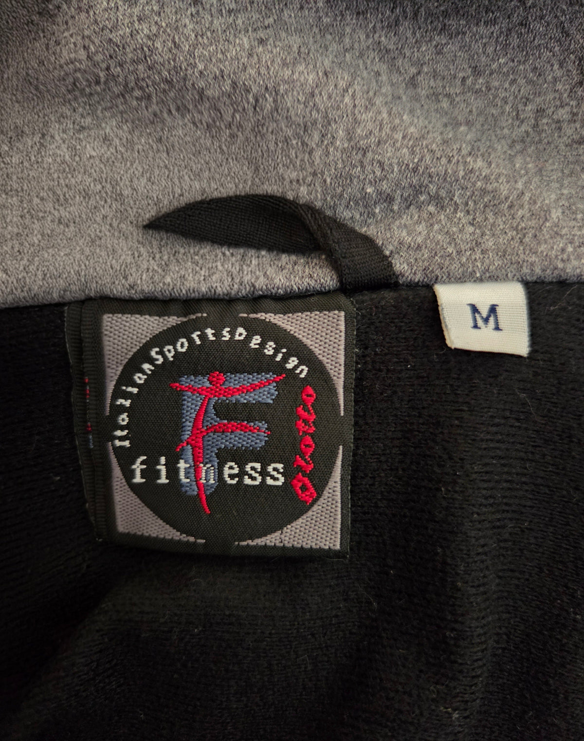 Close-up of a label on a piece of clothing with branding details.