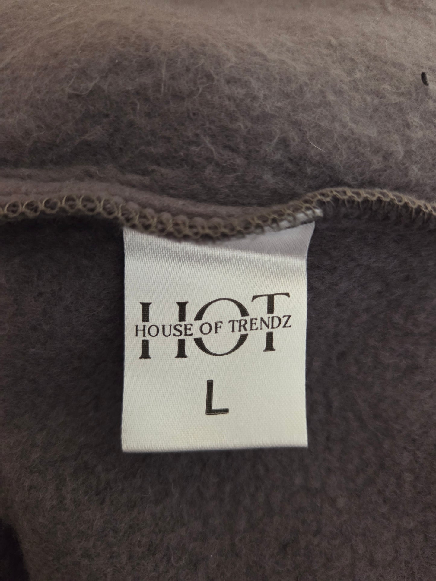 Close-up of a label with 'House of Trendz' text on a textured fabric background