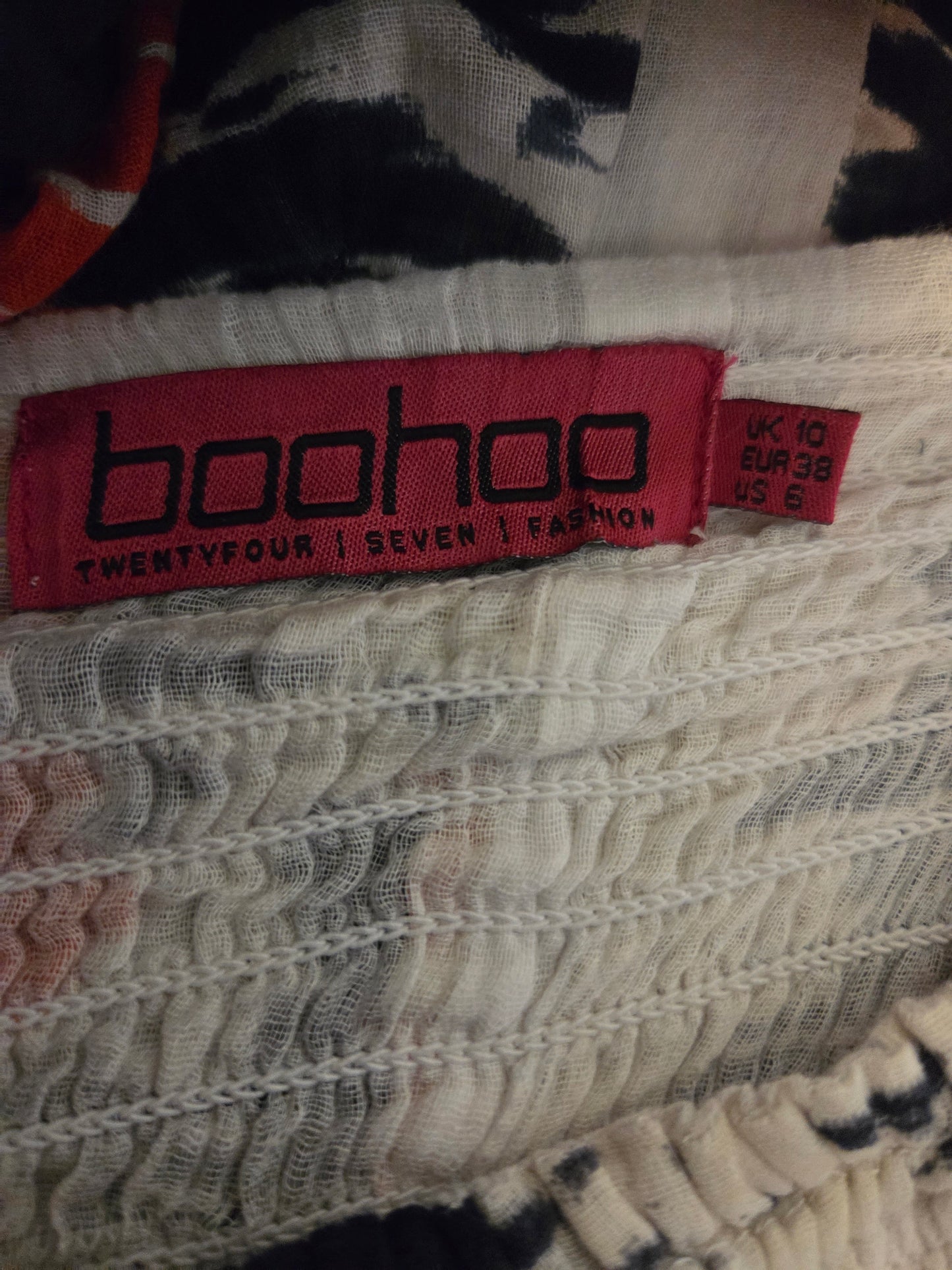 Boohoo label on a garment with a patterned background