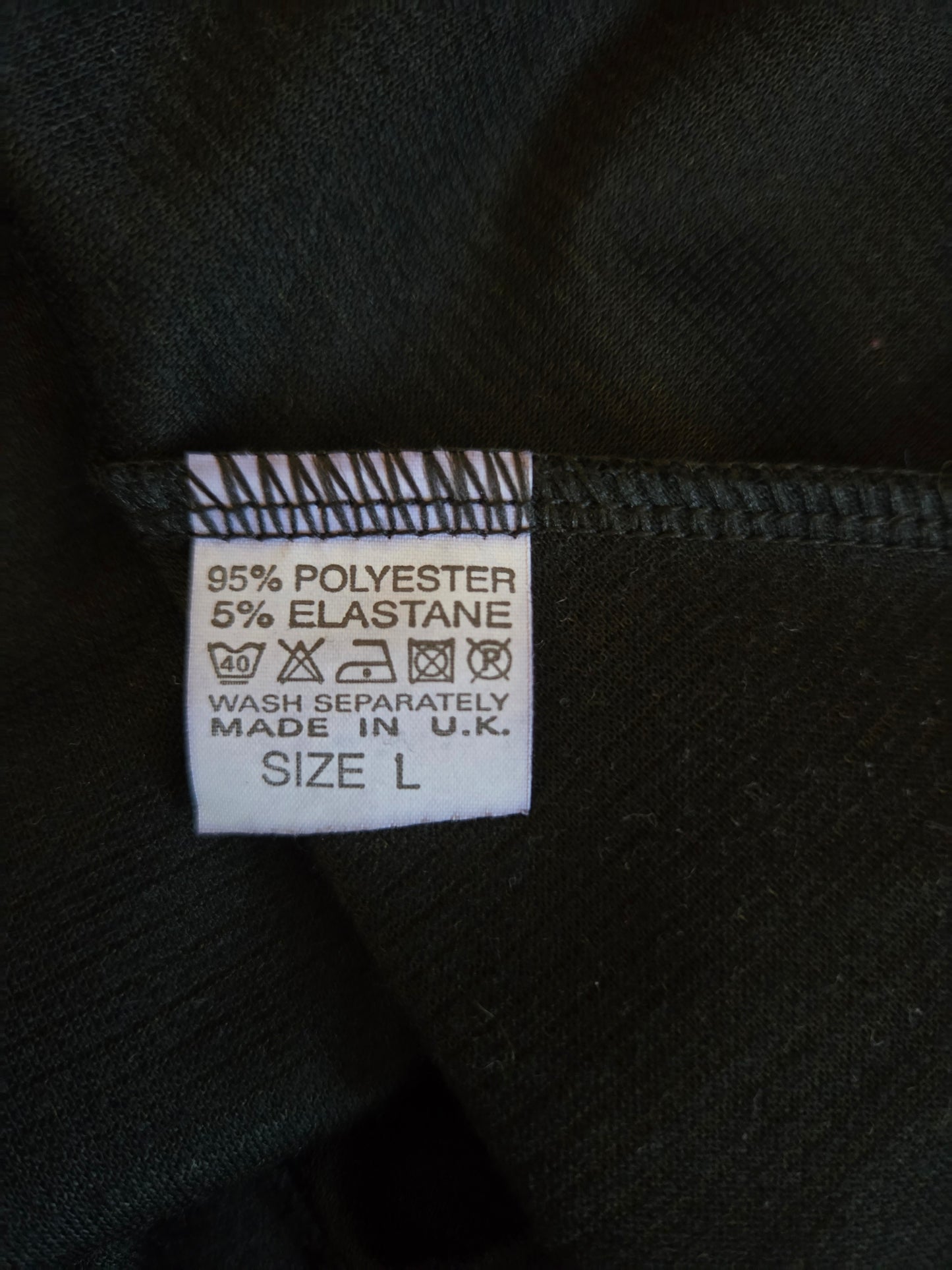 Clothing label with fabric composition and care instructions on a black background