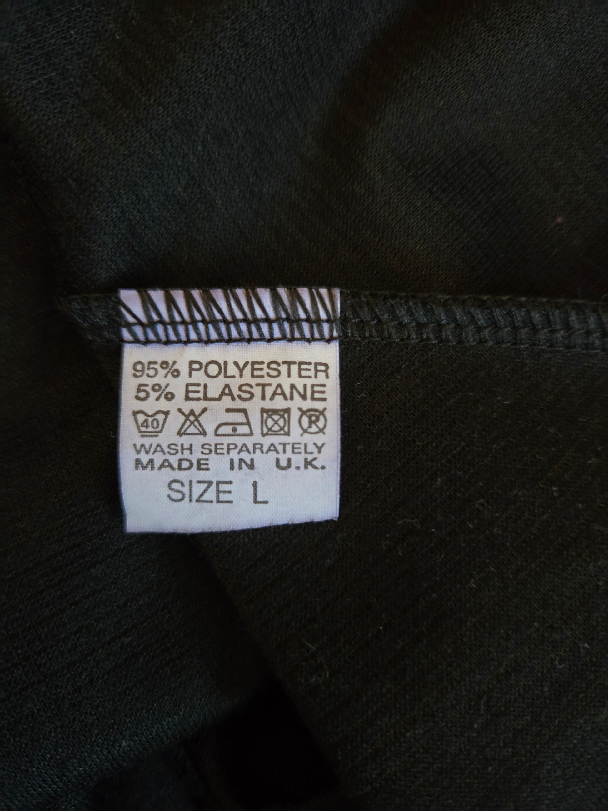 Clothing label with fabric composition and care instructions on a black background