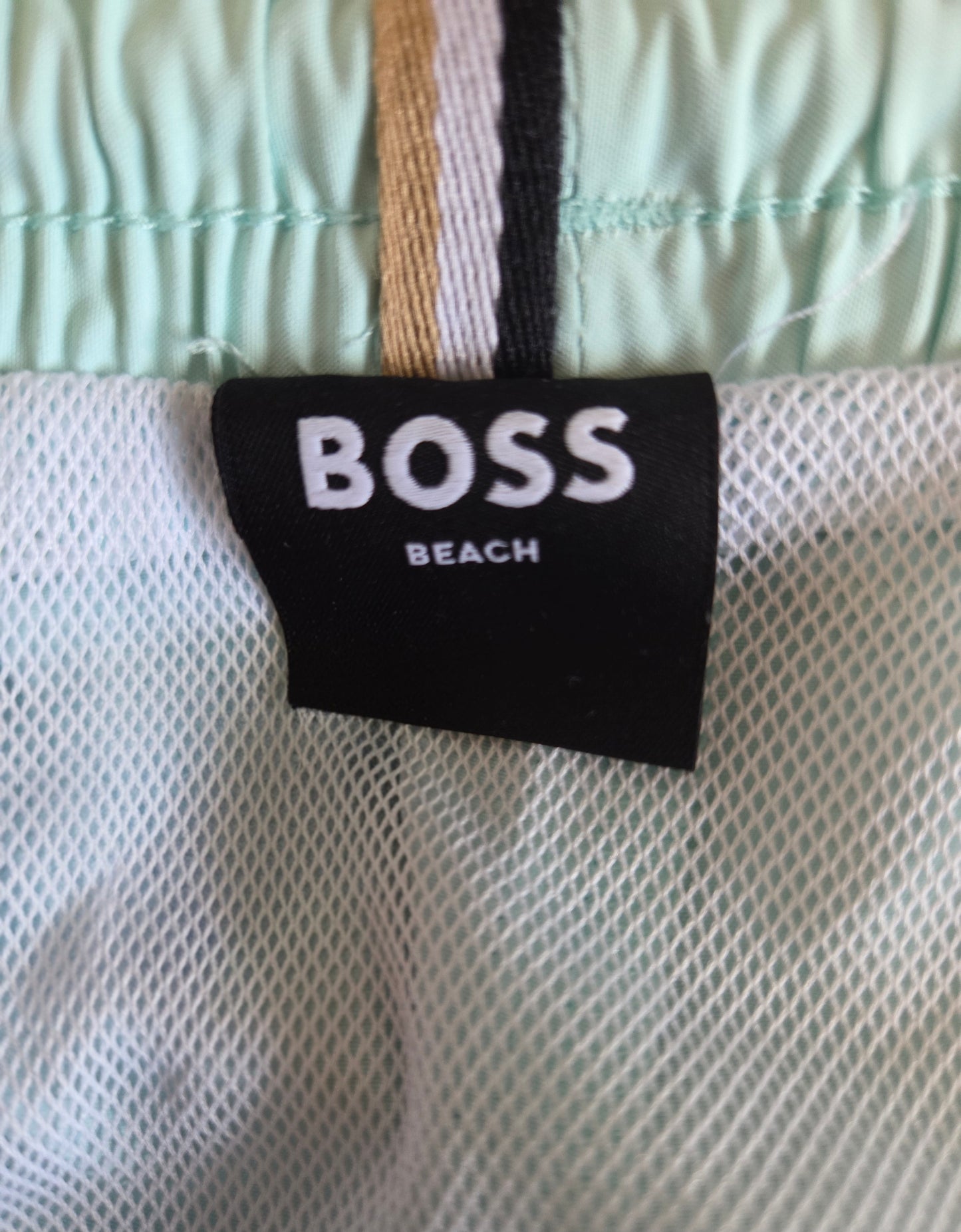 BOSS Beach label on a textured fabric background