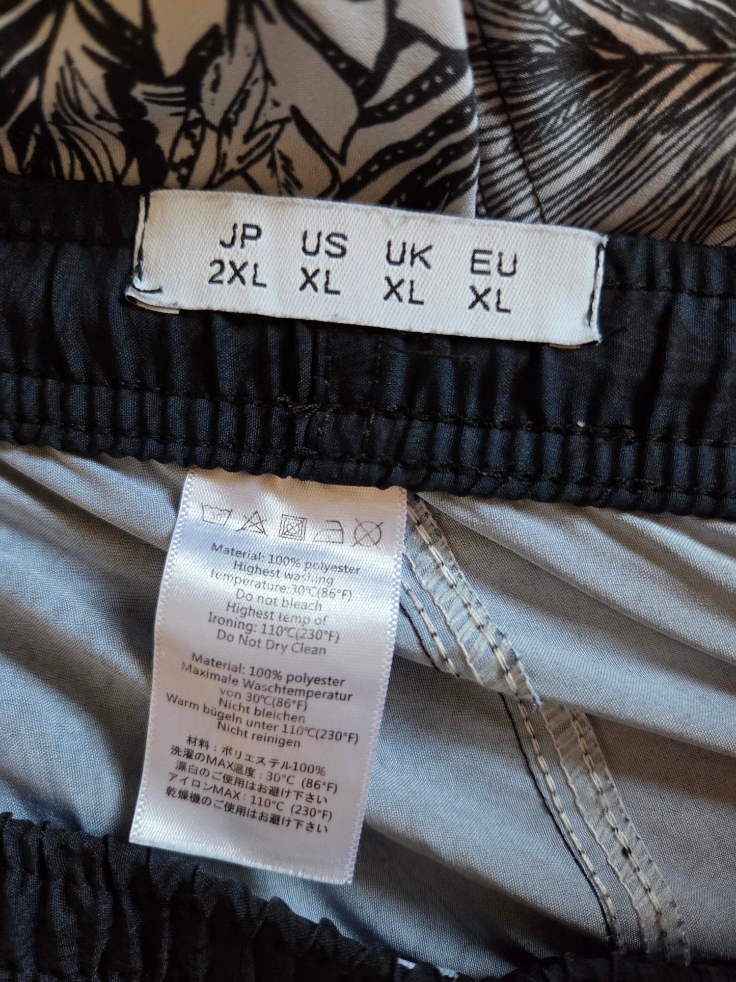 Close-up of clothing labels with size chart and care instructions on a garment.