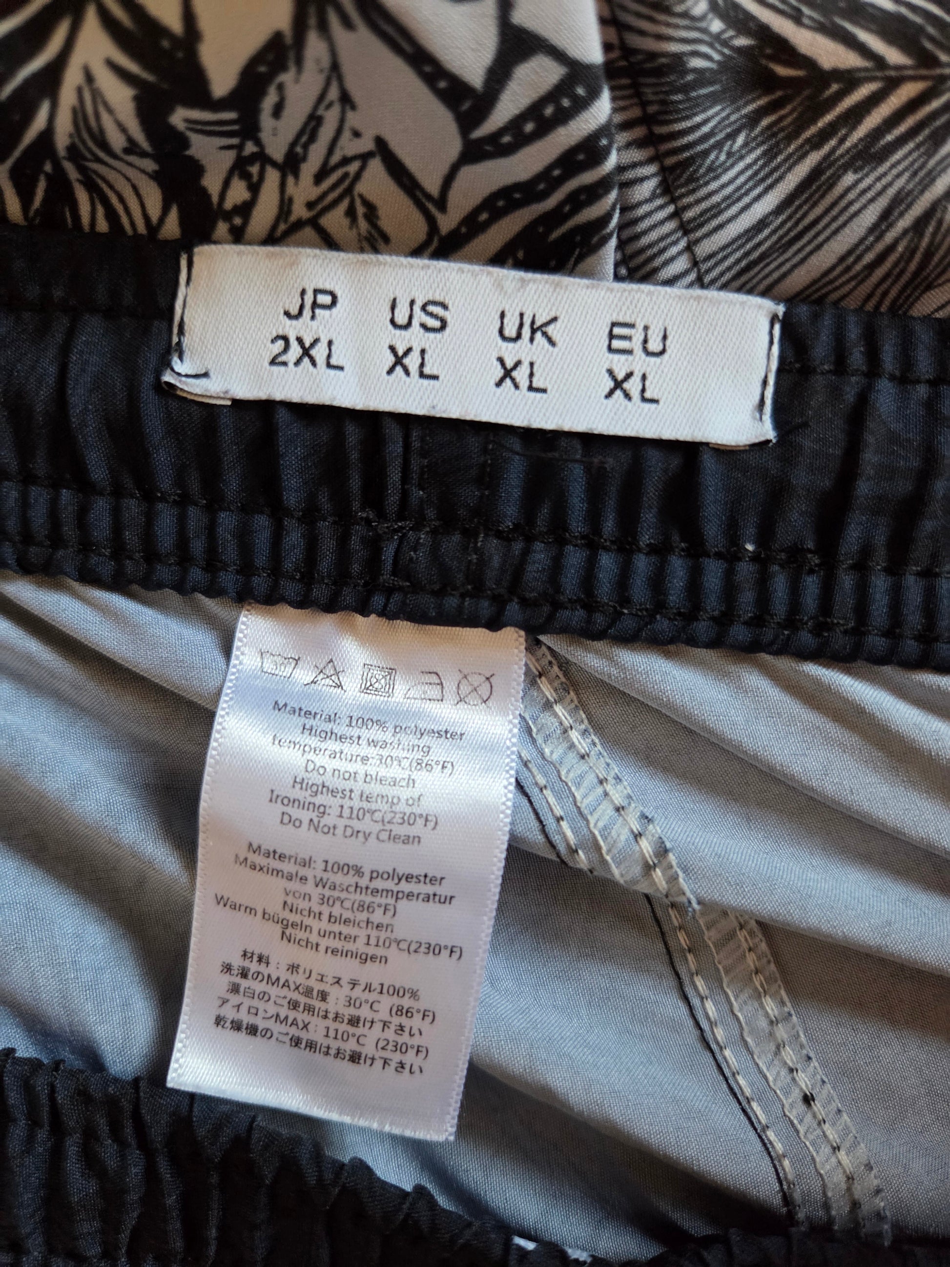 Close-up of clothing labels with size chart and care instructions on a garment.