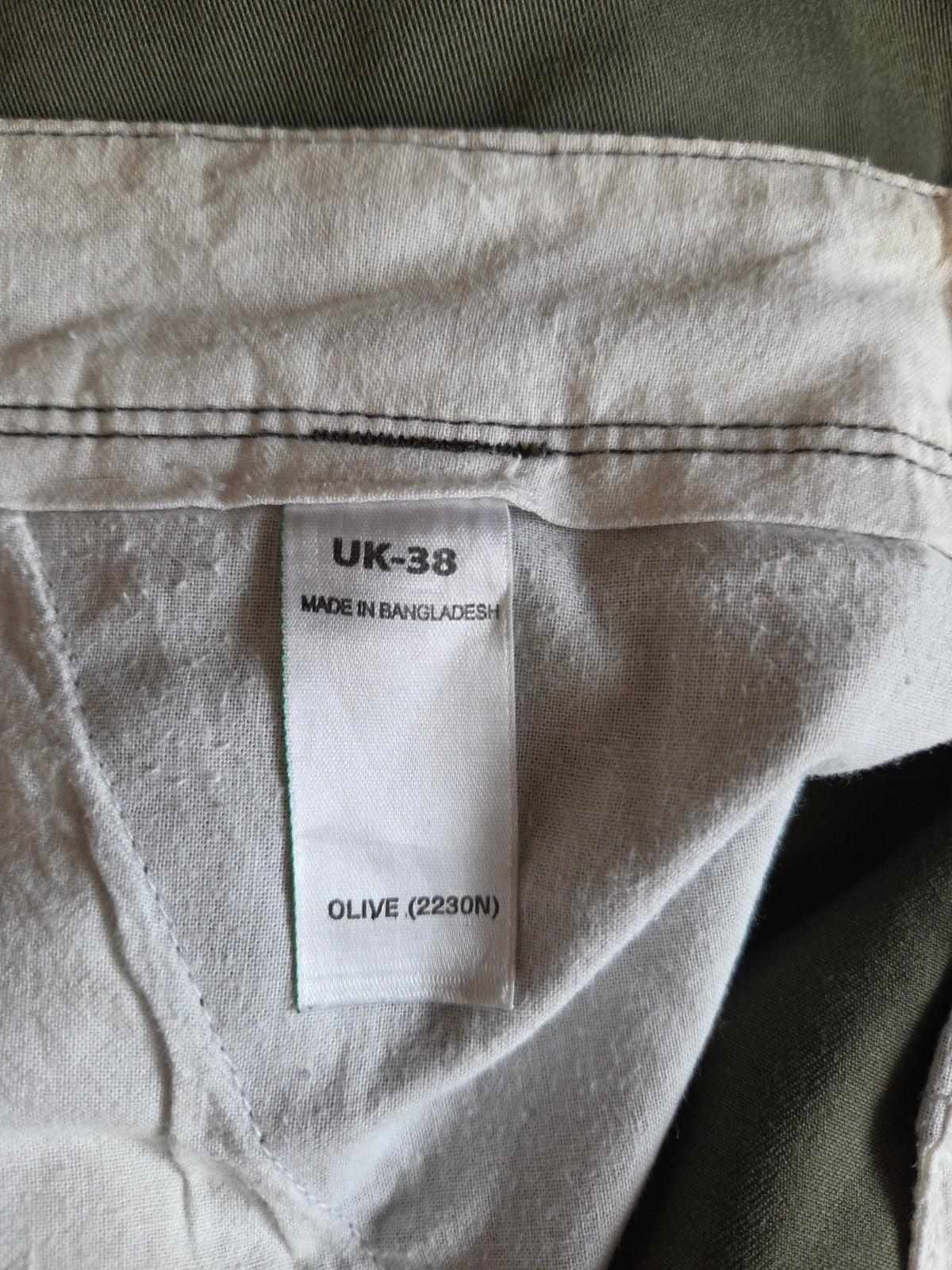 Close-up of a label on a piece of clothing with size and material information.