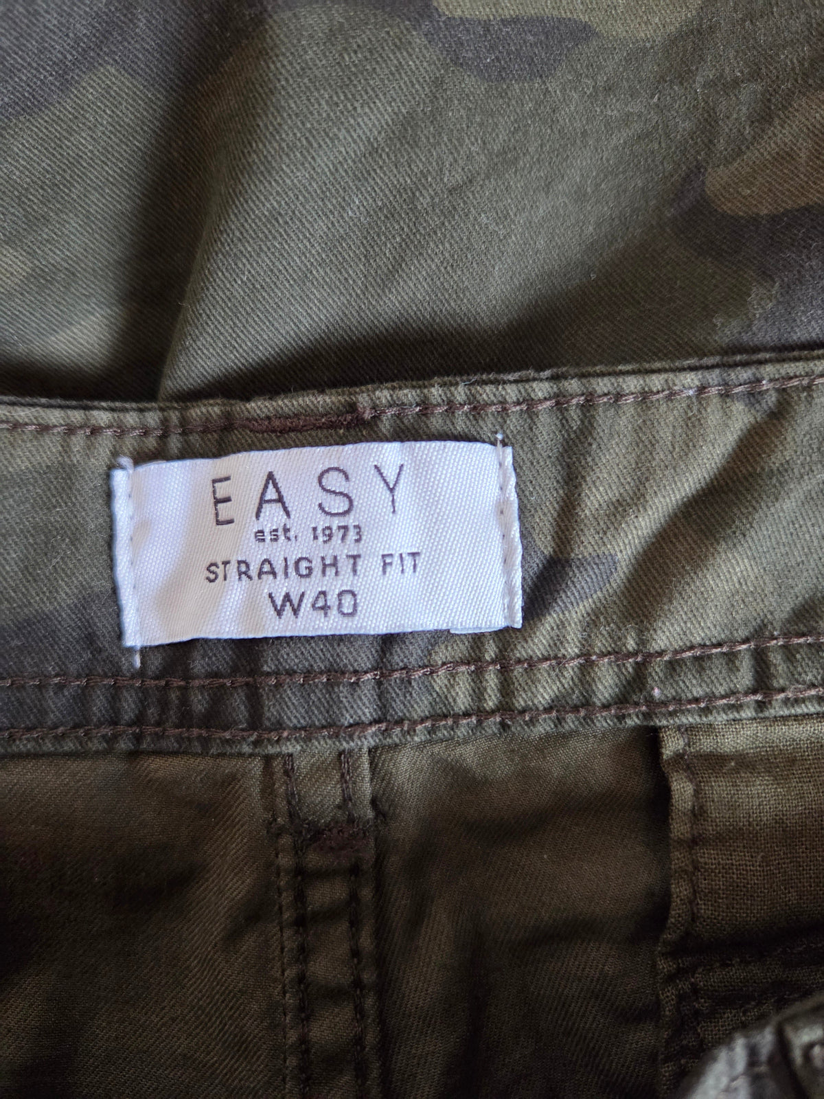 Camouflage pants with a 'Easy' brand label on the waistband.
