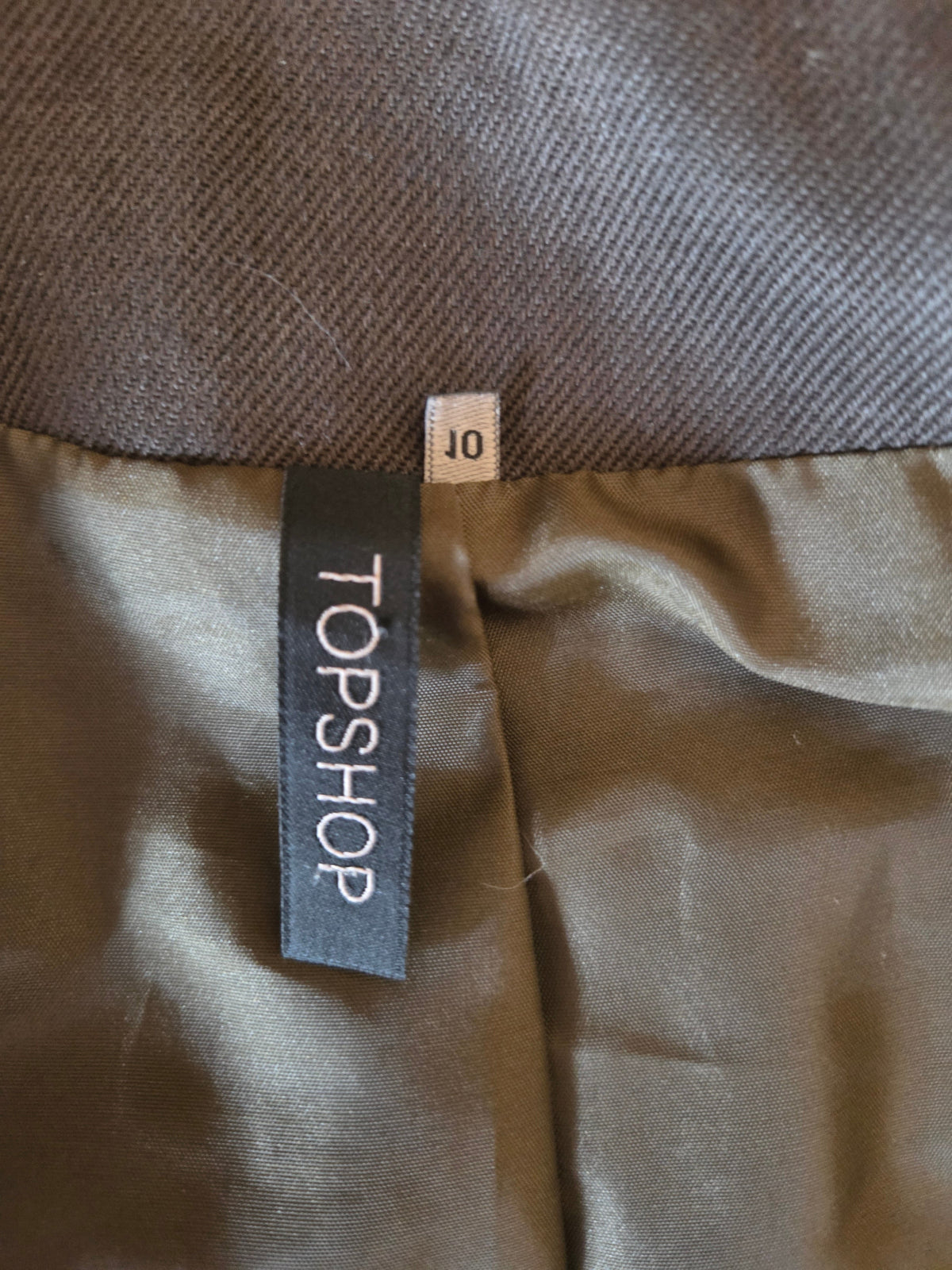 Topshop label on a brown fabric surface