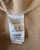 M&S size label on a beige fabric background