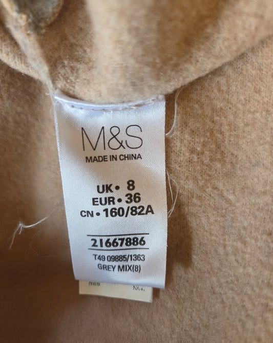 M&S size label on a beige fabric background