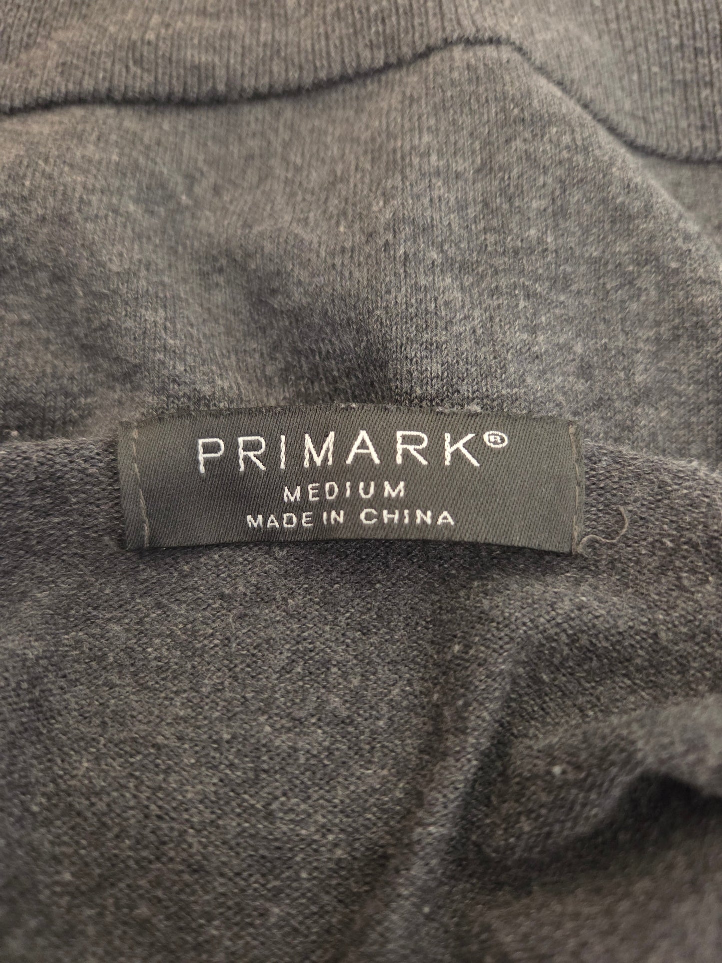Primark label on a gray fabric background