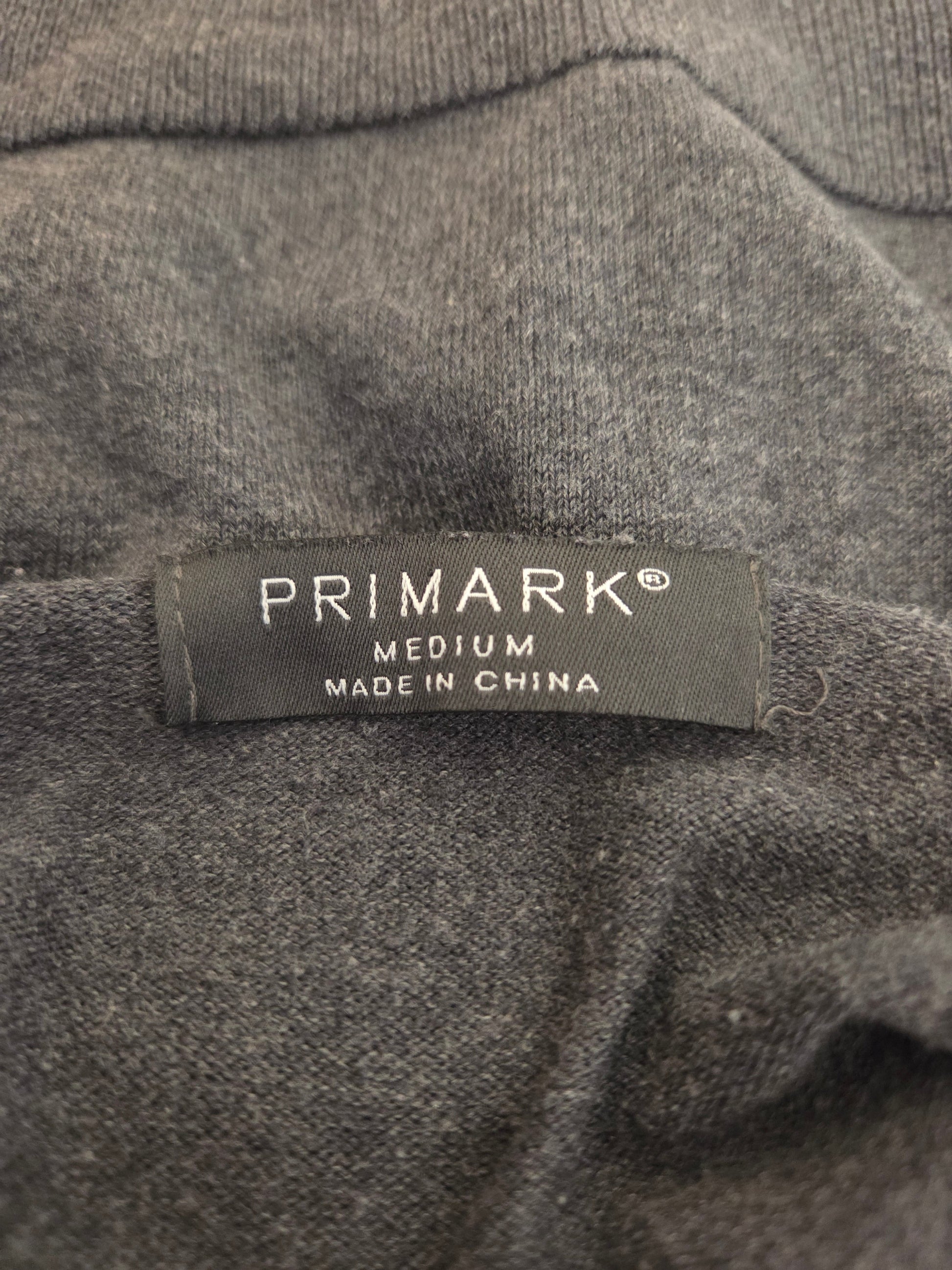 Primark label on a gray fabric background