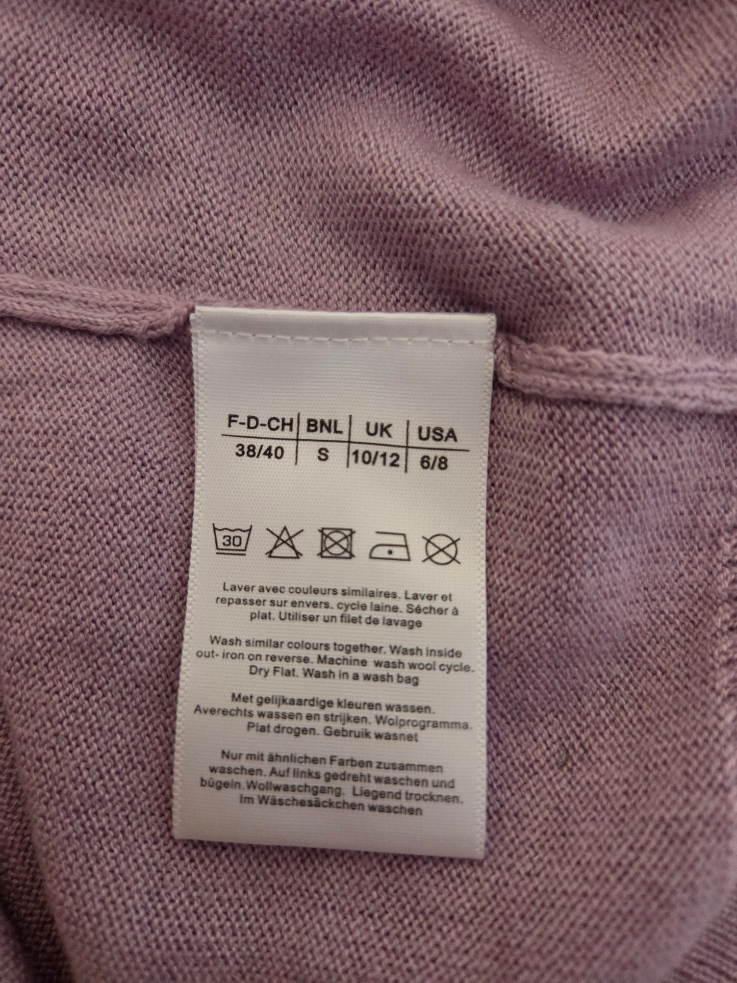 Close-up of a size label on a lilac fabric background