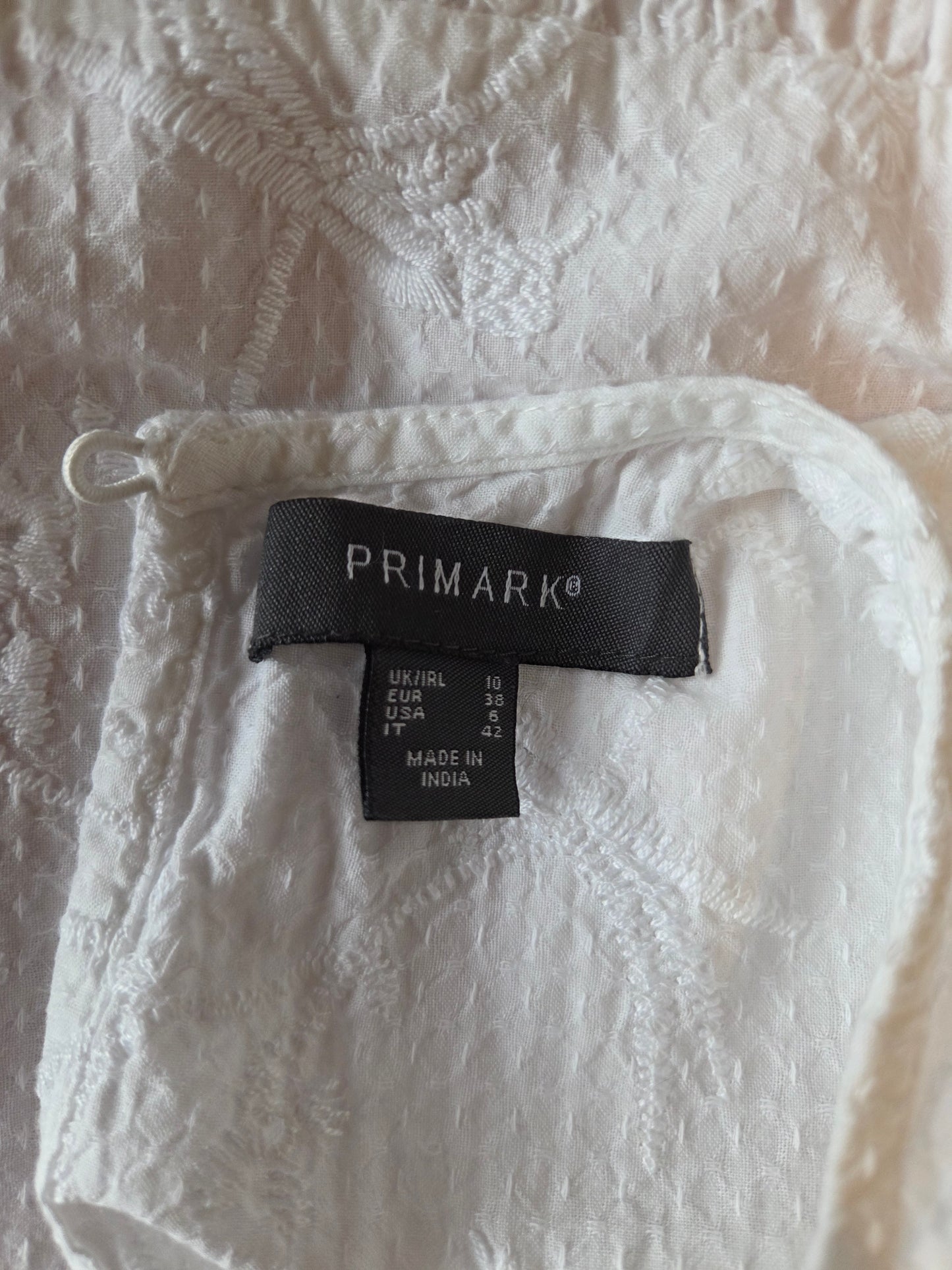White textured fabric with a Primark size label