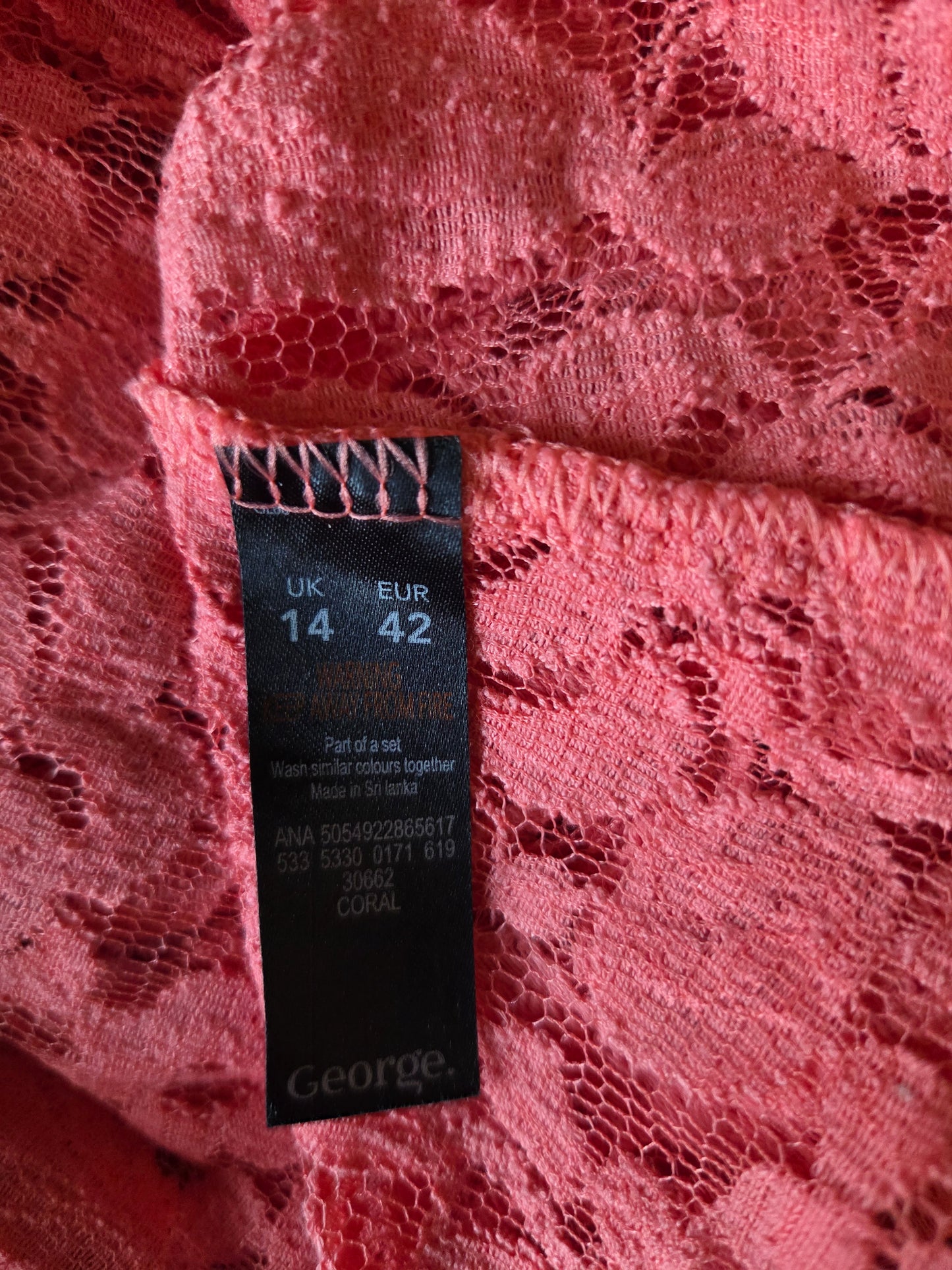 Close-up of a size tag on a pink lace background