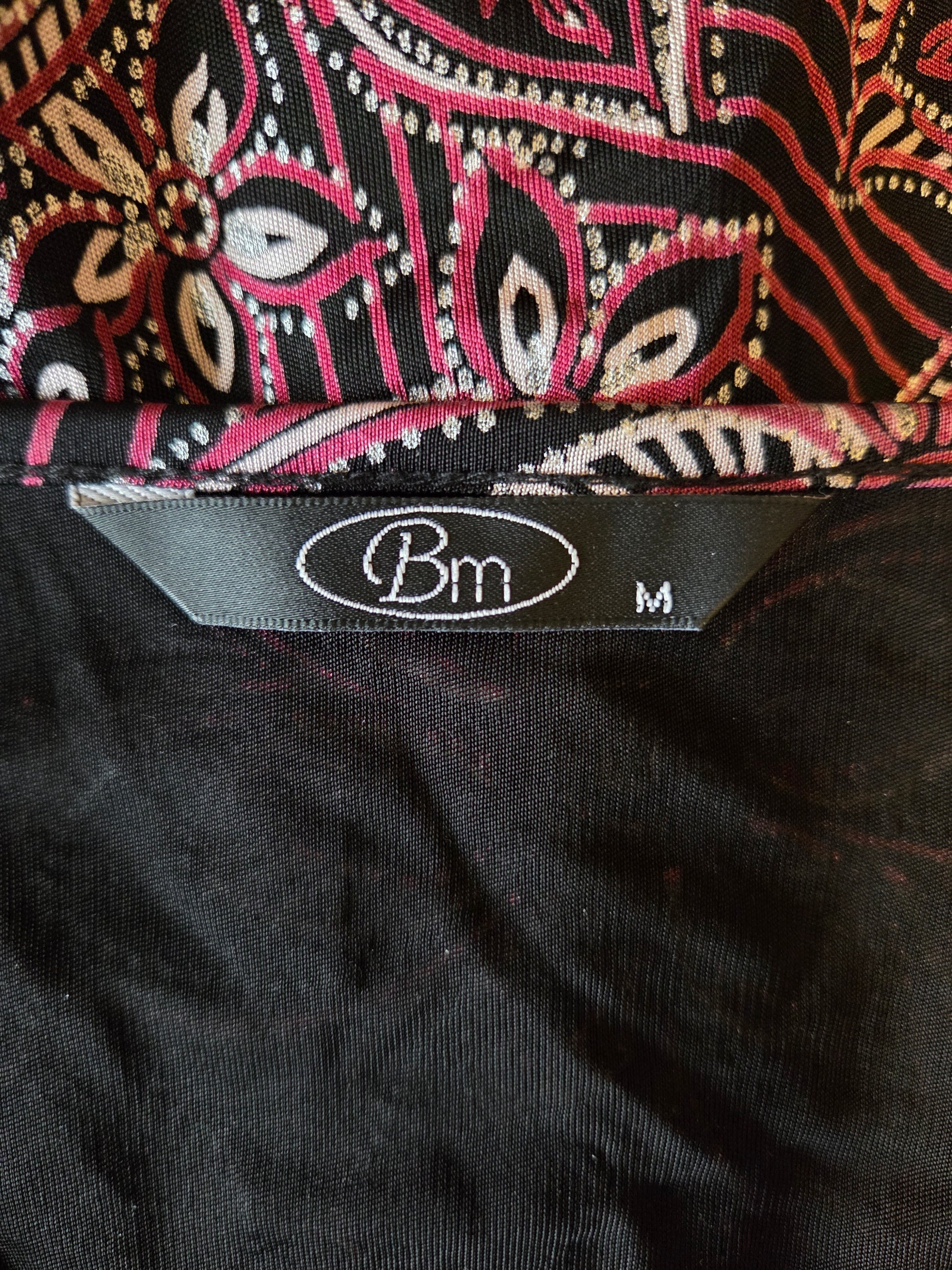 Close-up of a patterned fabric with a brand label on a black background