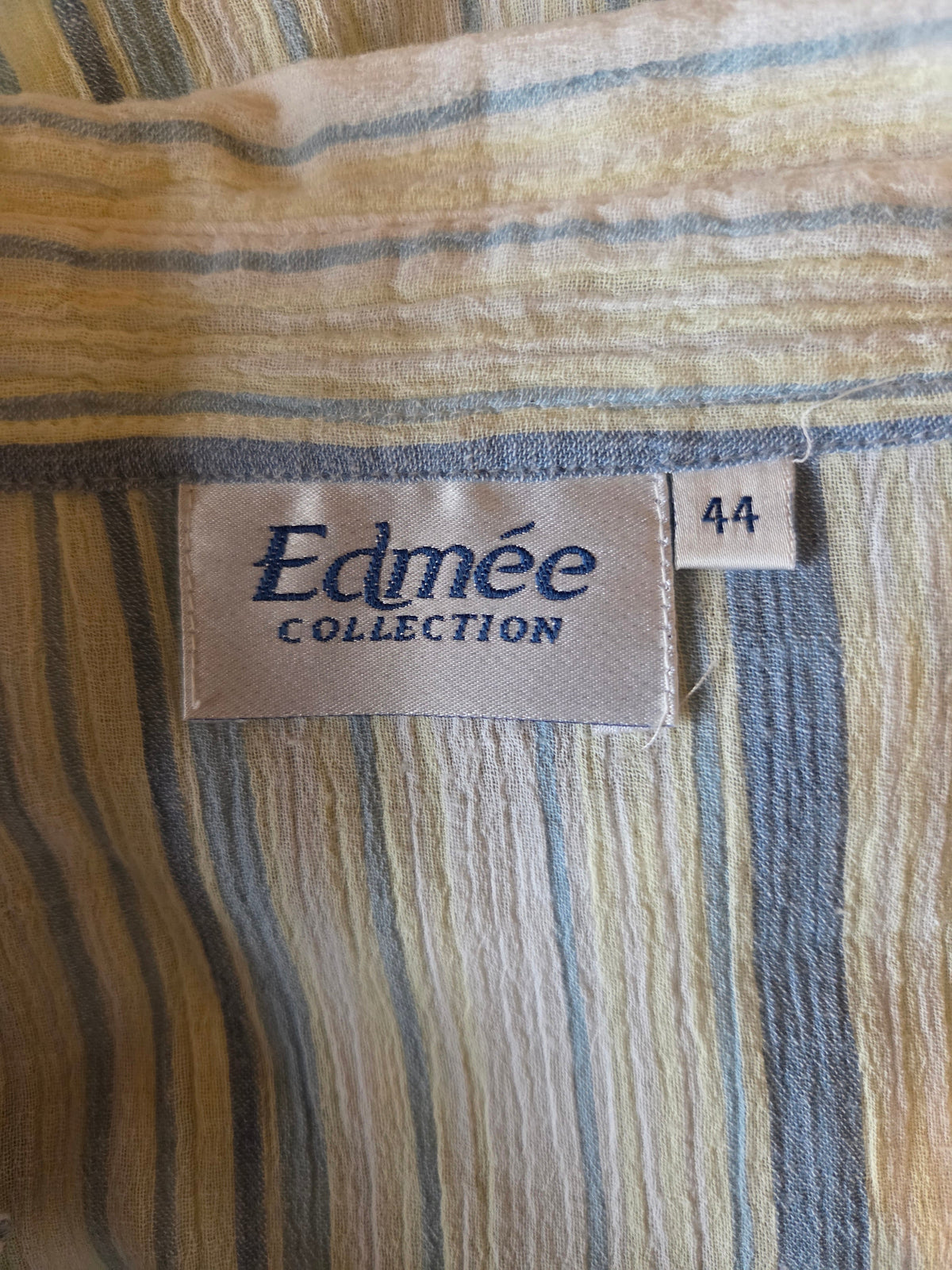 Close-up of a striped fabric with an Edmée Collection size label.