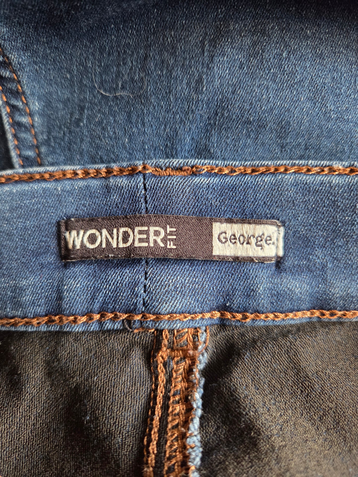 Close-up of a denim fabric with 'Wonder Fit George' label.