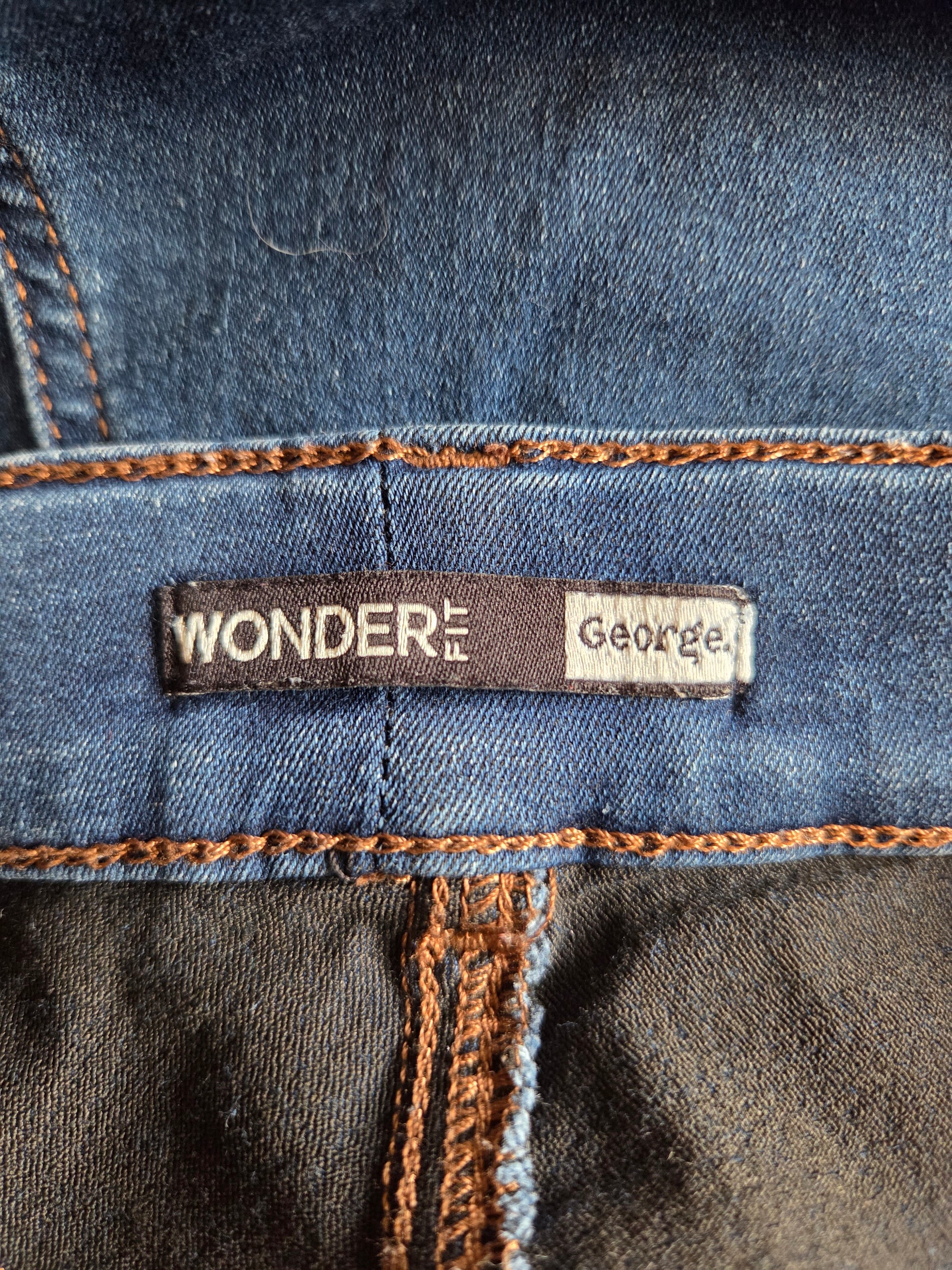 Close-up of a denim fabric with 'Wonder Fit George' label.