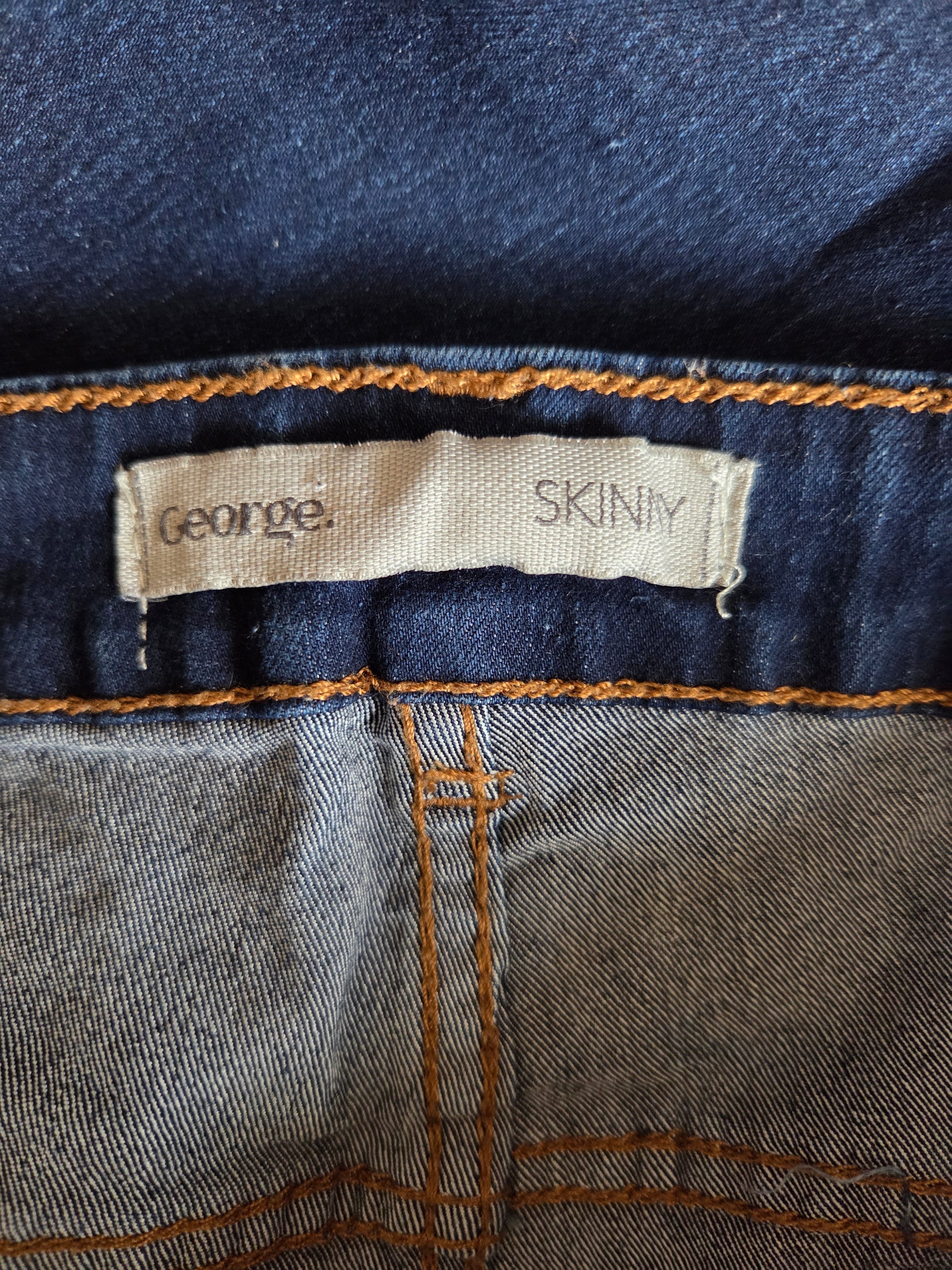 Close-up of a denim label on a pair of jeans with 'George' branding.