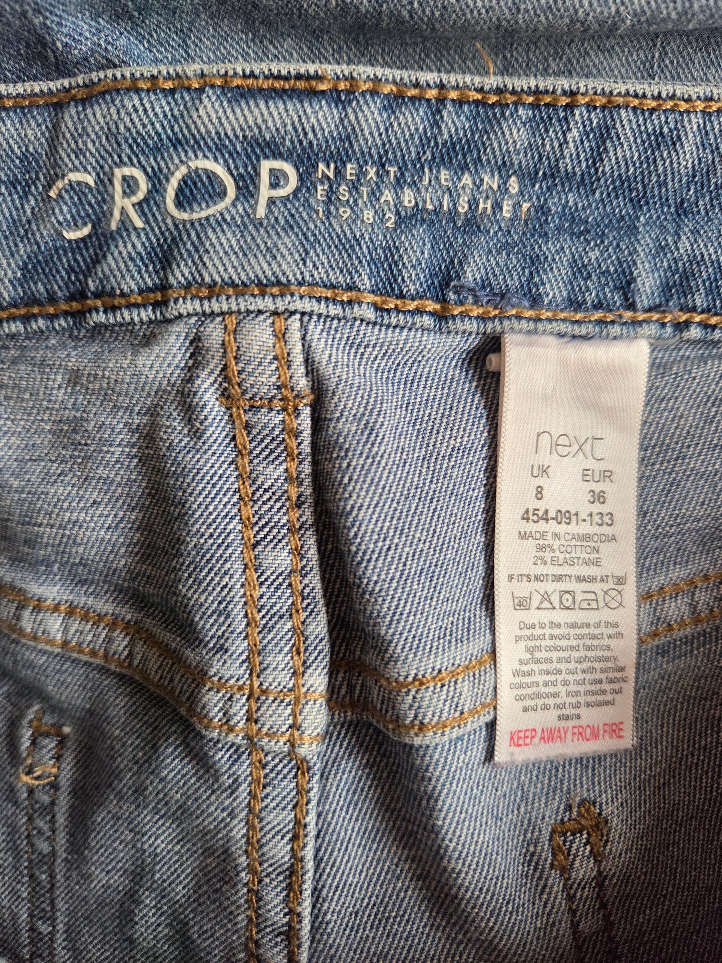 Close-up of a denim fabric with a brand label on a blue jeans background