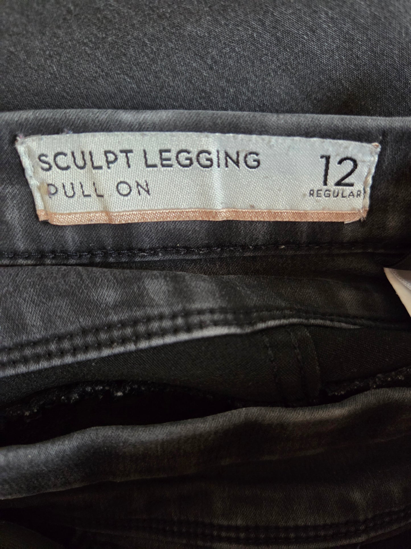 black leggings with a size label on a dark background