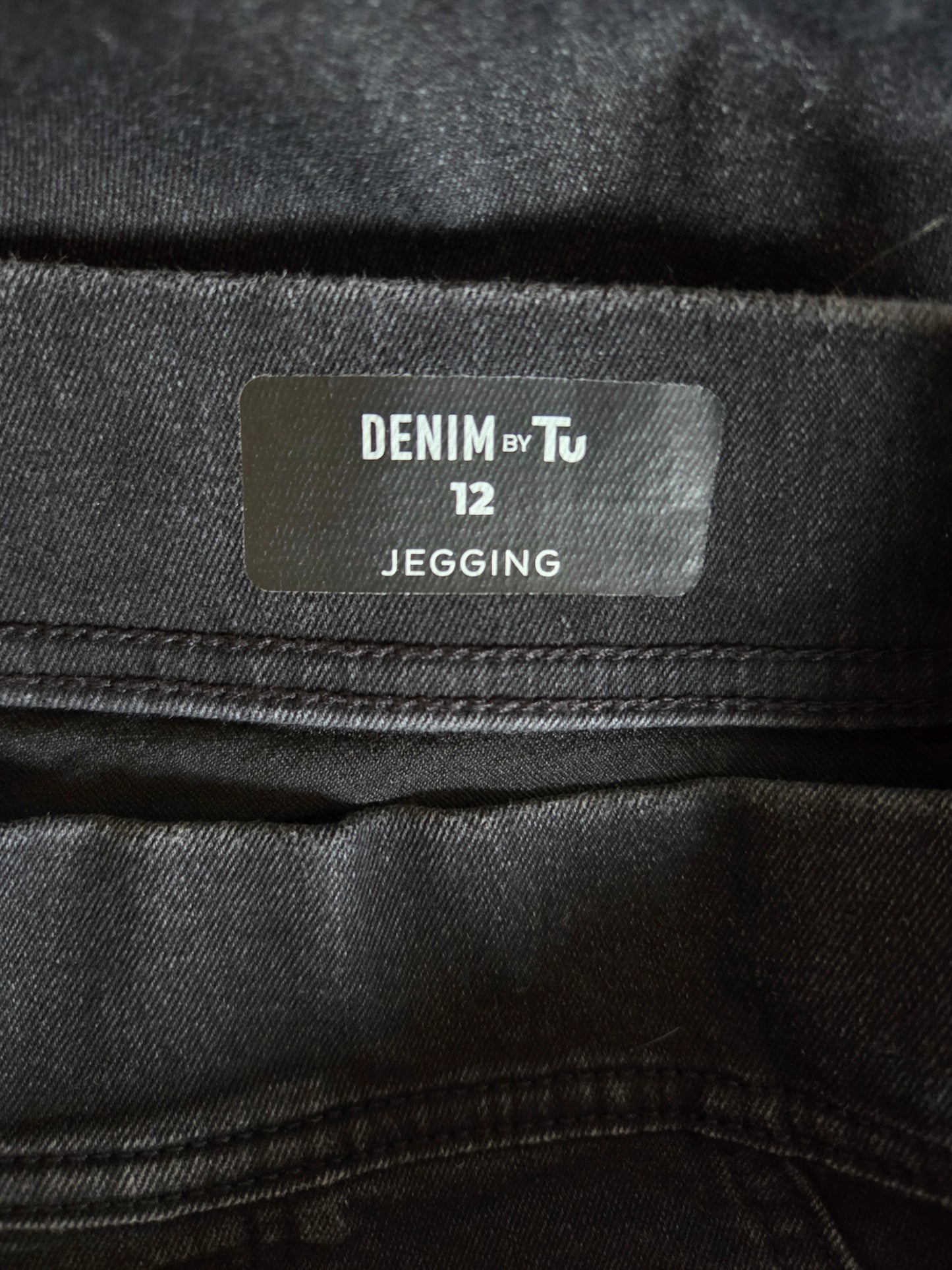 Close-up of a denim label on black denim fabric