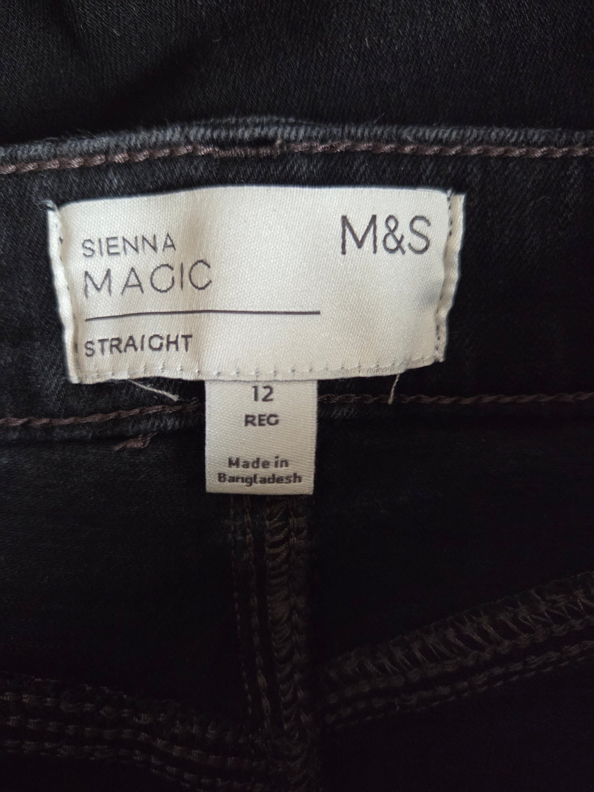 Black jeans with M&S label showing 'Sienna Magic' and size information.