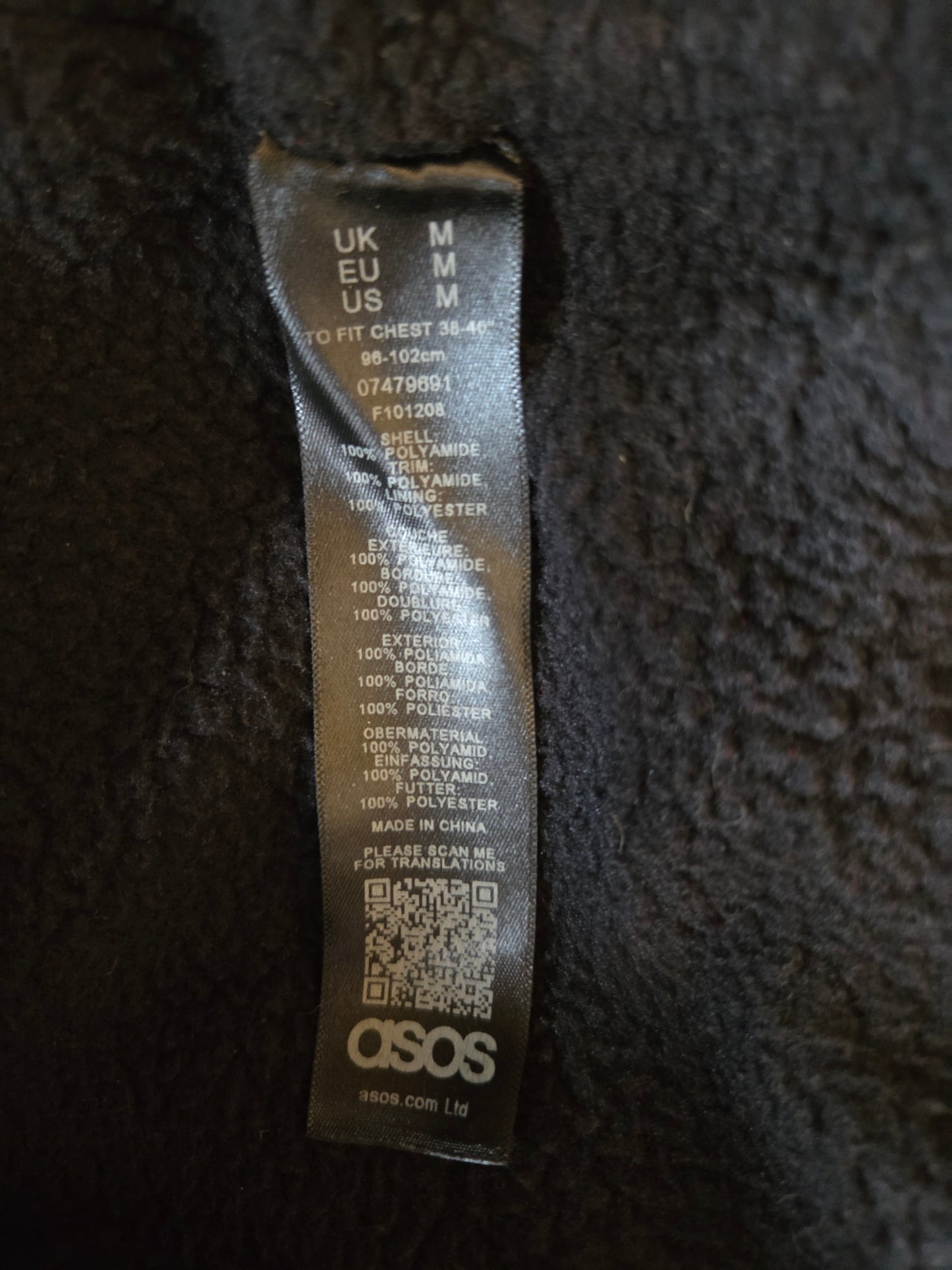 Close-up of a label on dark fabric with text and a qr code