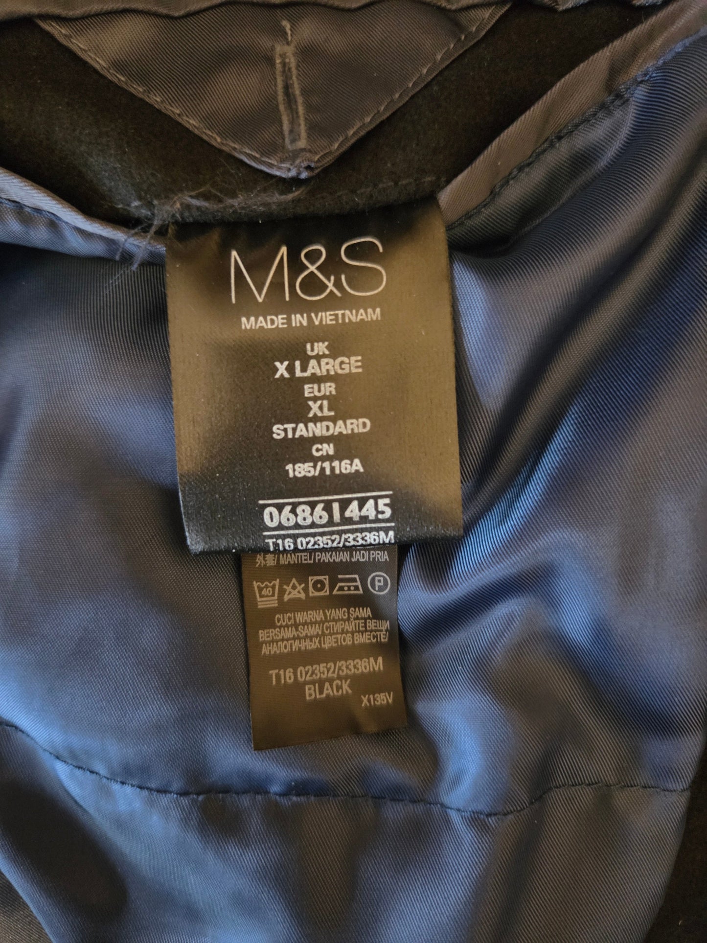 M&S label on a jacket with size and care instructions.