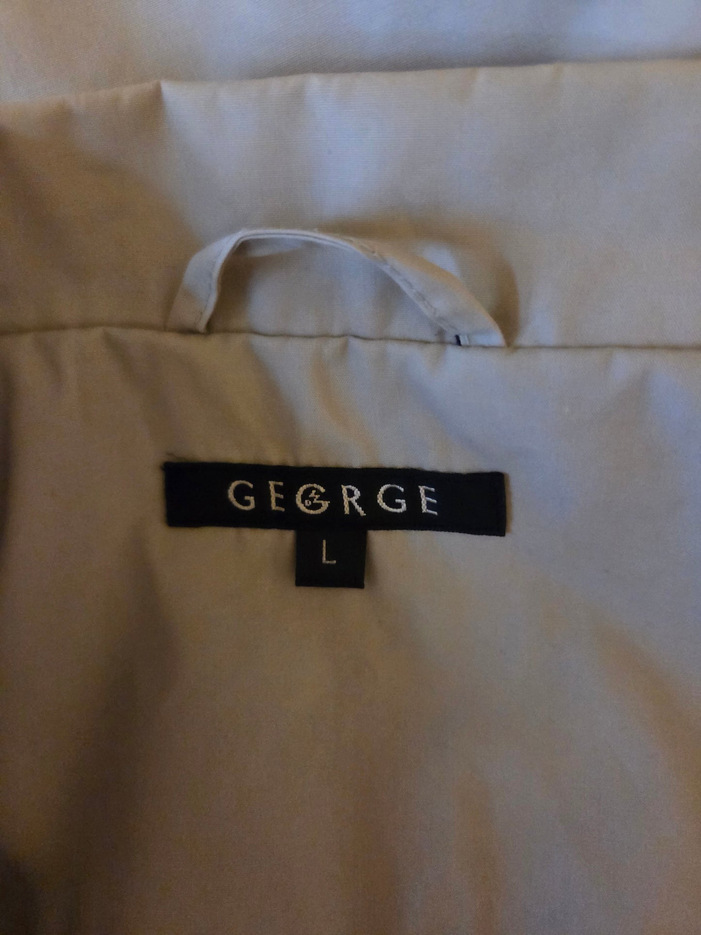 Close-up of a beige shirt with a 'GEORGE' label 