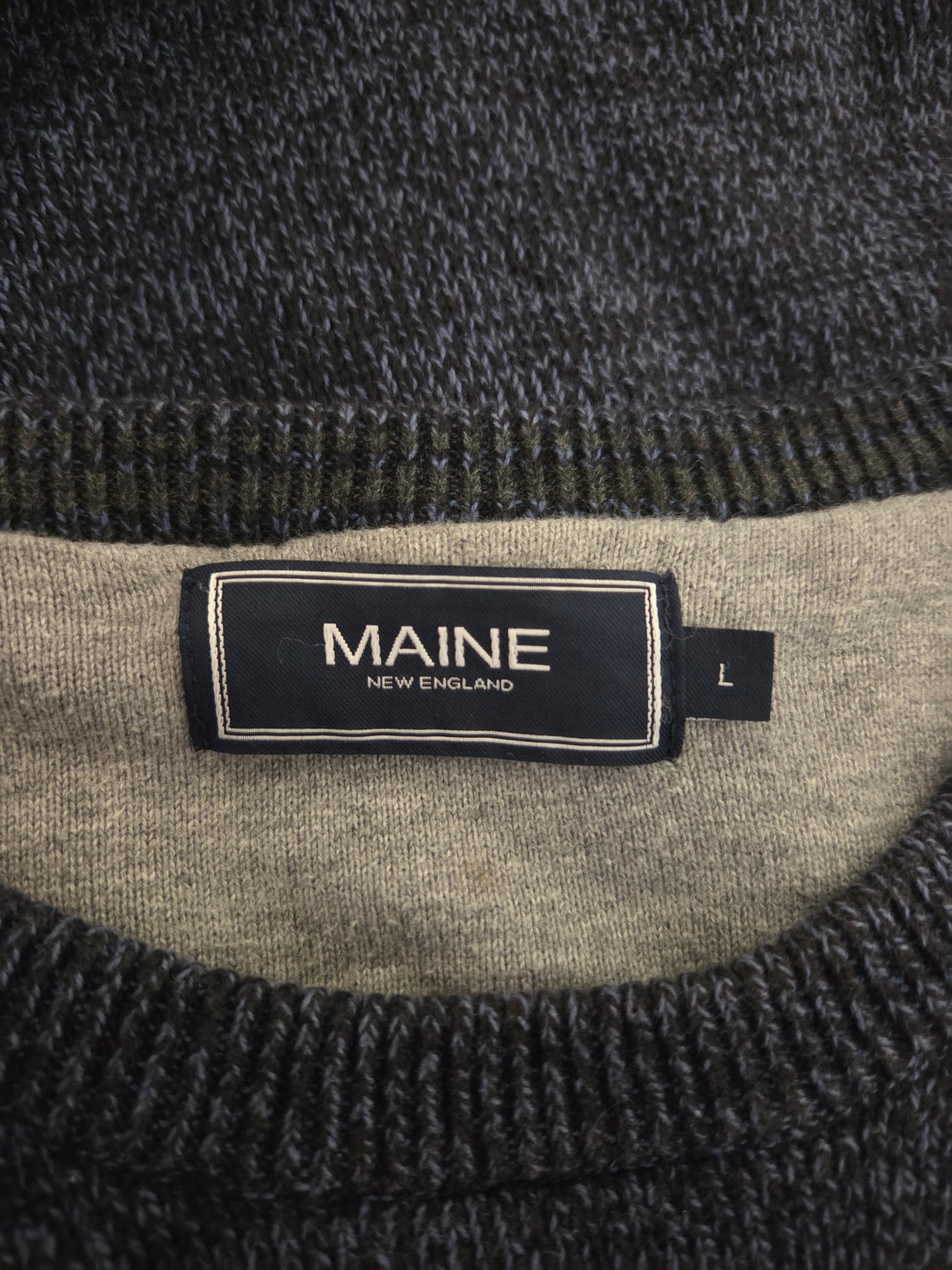 Close-up of a label on a textured fabric with 'MAINE' text.