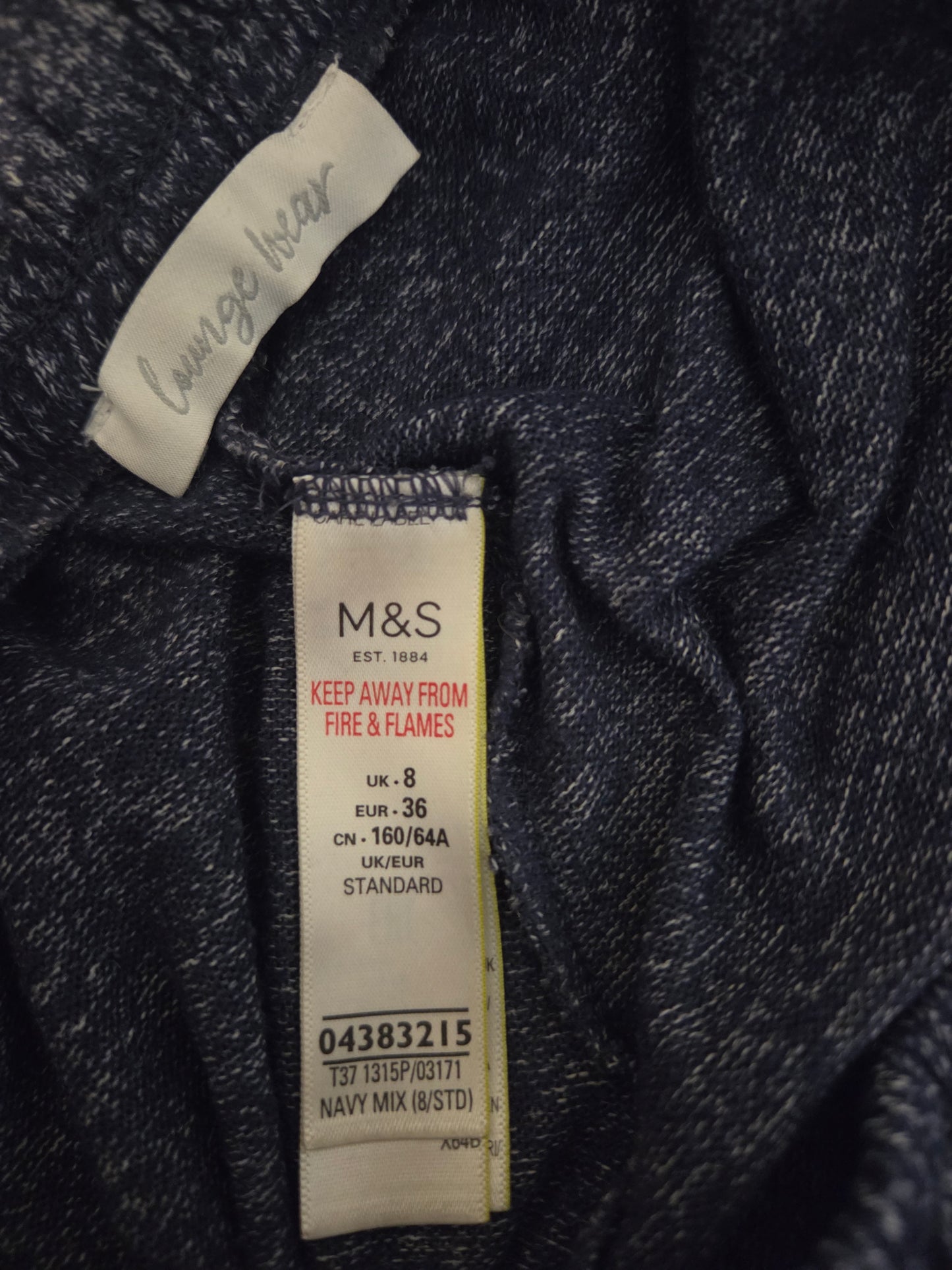 Close-up of a M&S size label on a dark fabric background